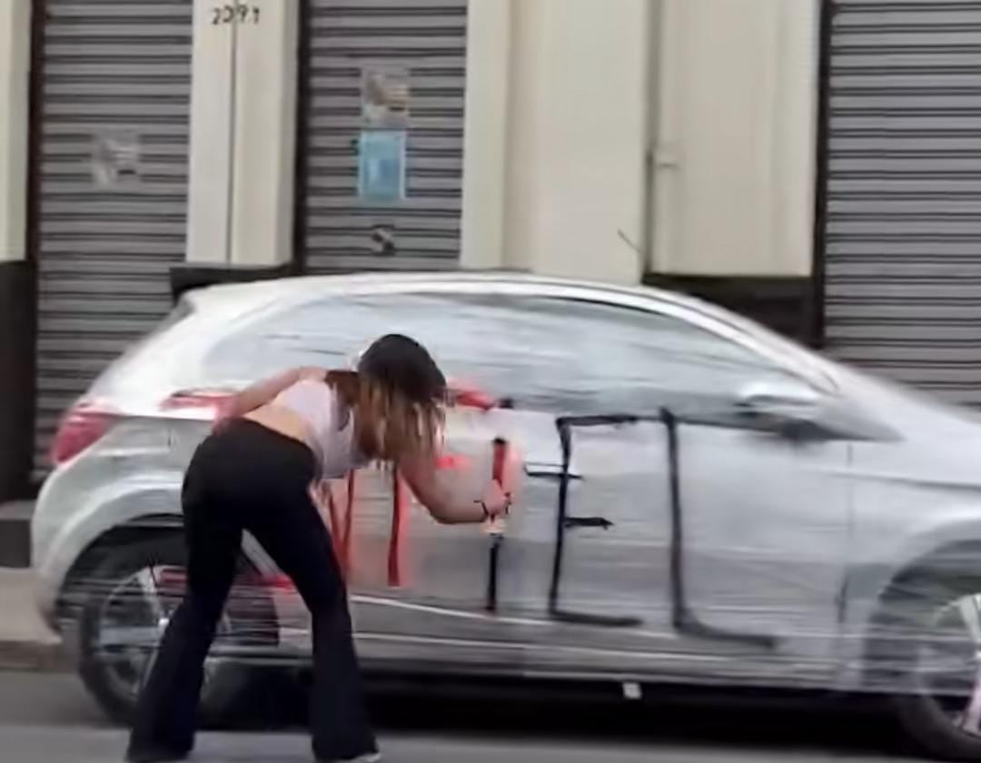 La joven fue captada mientras escribía “infiel” con spray en el carro de su pareja.