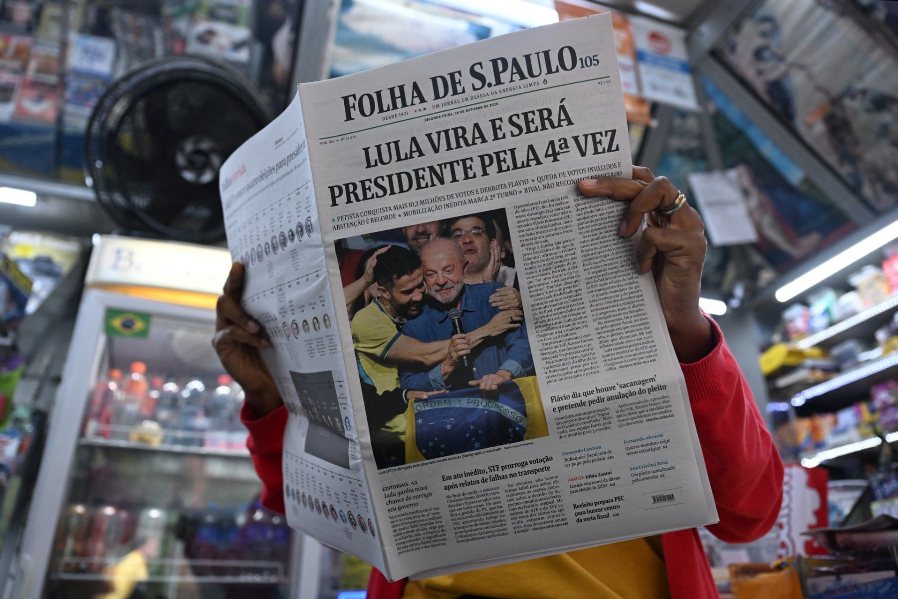 Una mujer lee un periódico cuya portada destaca la victoria del presidente de Brasil y candidato a la reelección, Luiz Inácio Lula da Silva, un día después de la segunda ronda de las elecciones presidenciales, en São Paulo, Brasil.