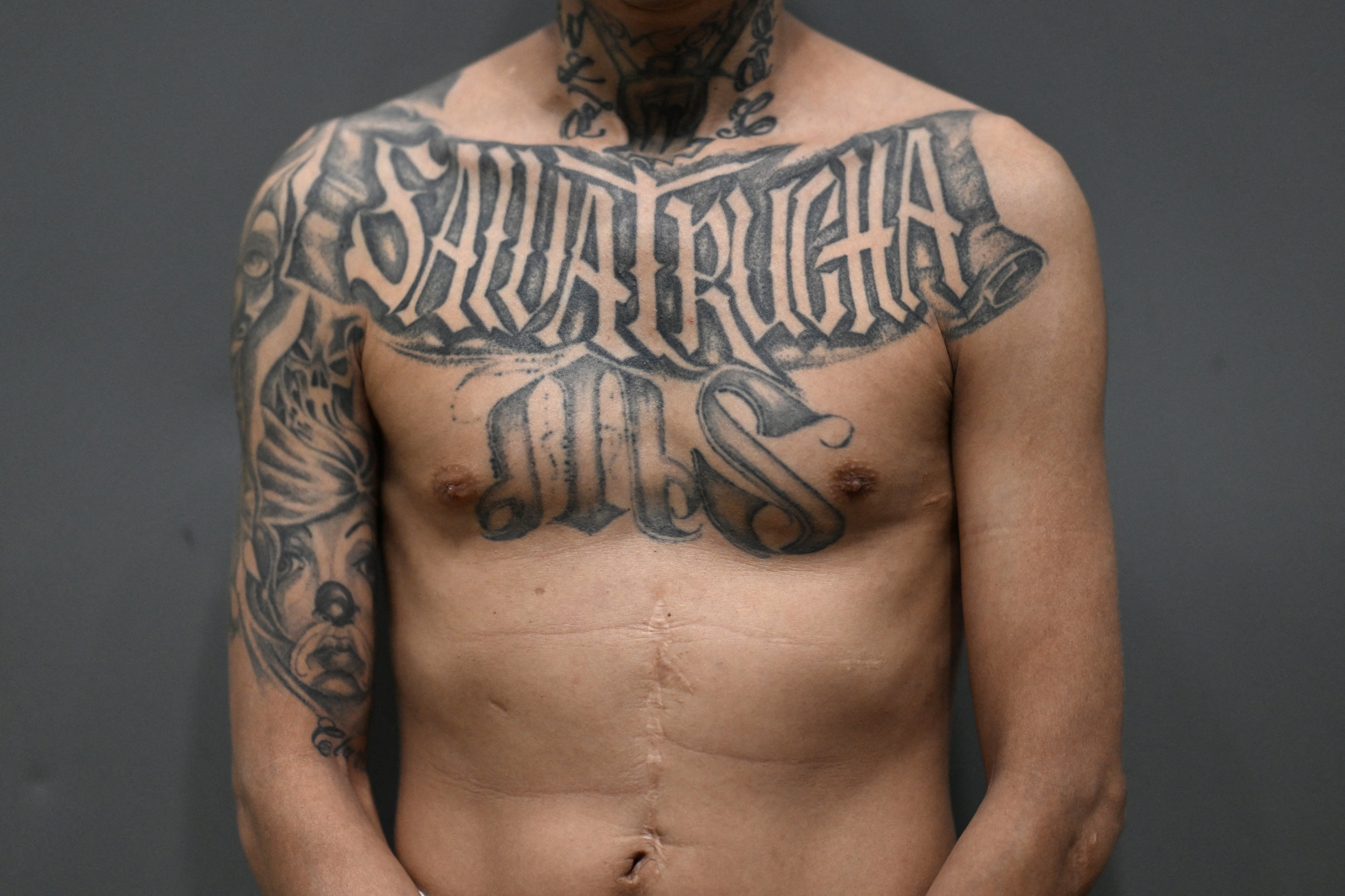 Un pandillero de la Mara Salvatrucha (MS-13) sentenciado a más de 200 años de prisión muestra sus tatuajes alusivos a su pandilla dentro del megacárcel Centro de Internamiento Antiterrorista (CECOT), donde se encuentran recluidos cientos de miembros de las pandillas MS-13 y Calle 18, en Tecoluca, El Salvador.
