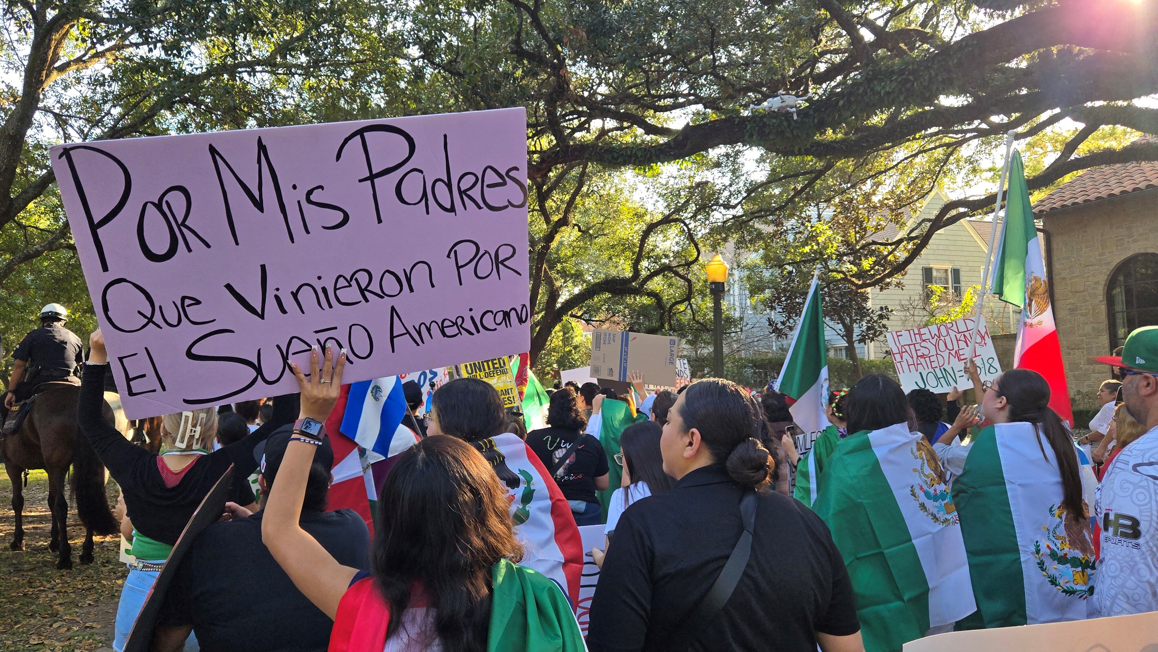 Una mujer sostiene un cartel que dice: 'Por mis padres que vinieron por el sueño americano', durante la protesta de los migrantes en Houston.