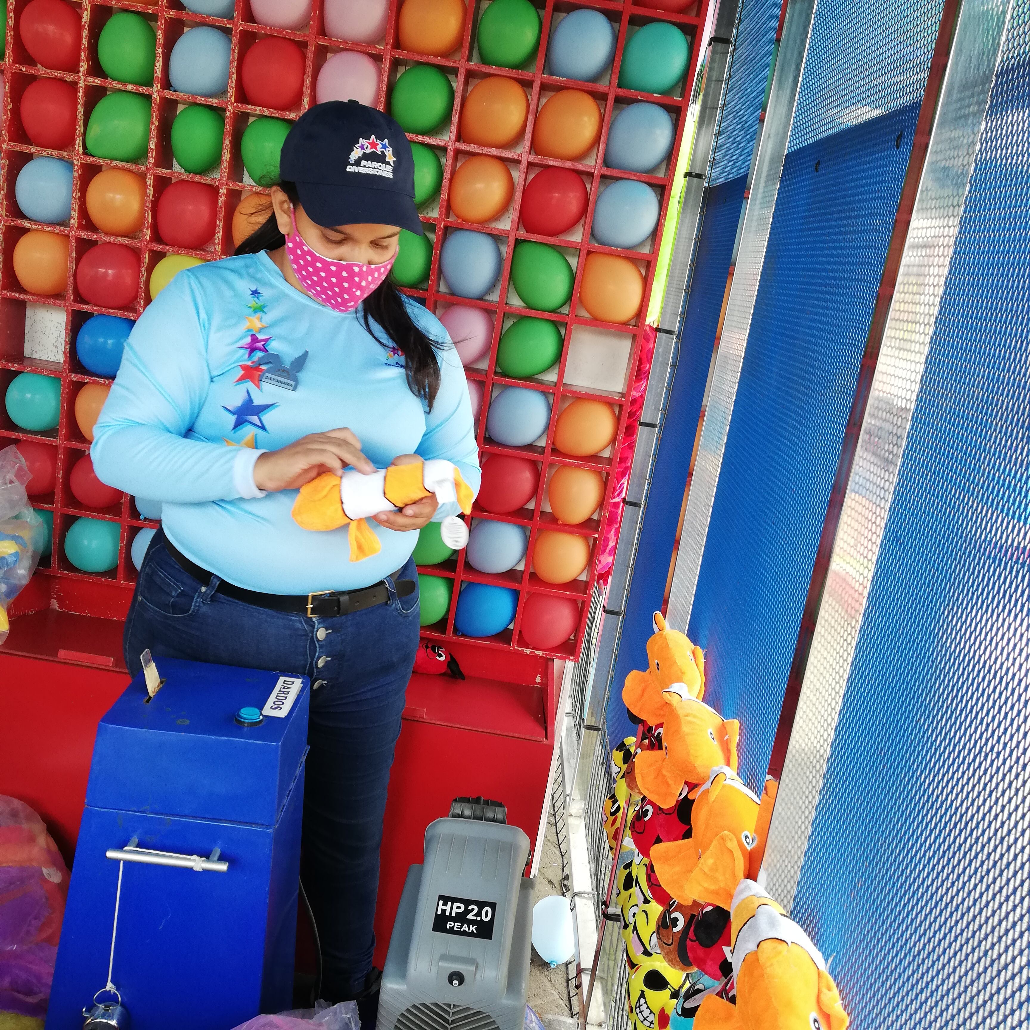 El 1 de diciembre, y después de 20 meses cerrado por la pandemia, el Parque Nacional de Diversiones reabre sus puertas al público, bajo estrictos protocolos higiénicos; el 17 de noviembre los visitamos para ver los avances en la puesta a punto de las 30 atracciones. Dayanara Cedeño, alista los peluches de regalo para quienes busquen probar suerte en los dardos.