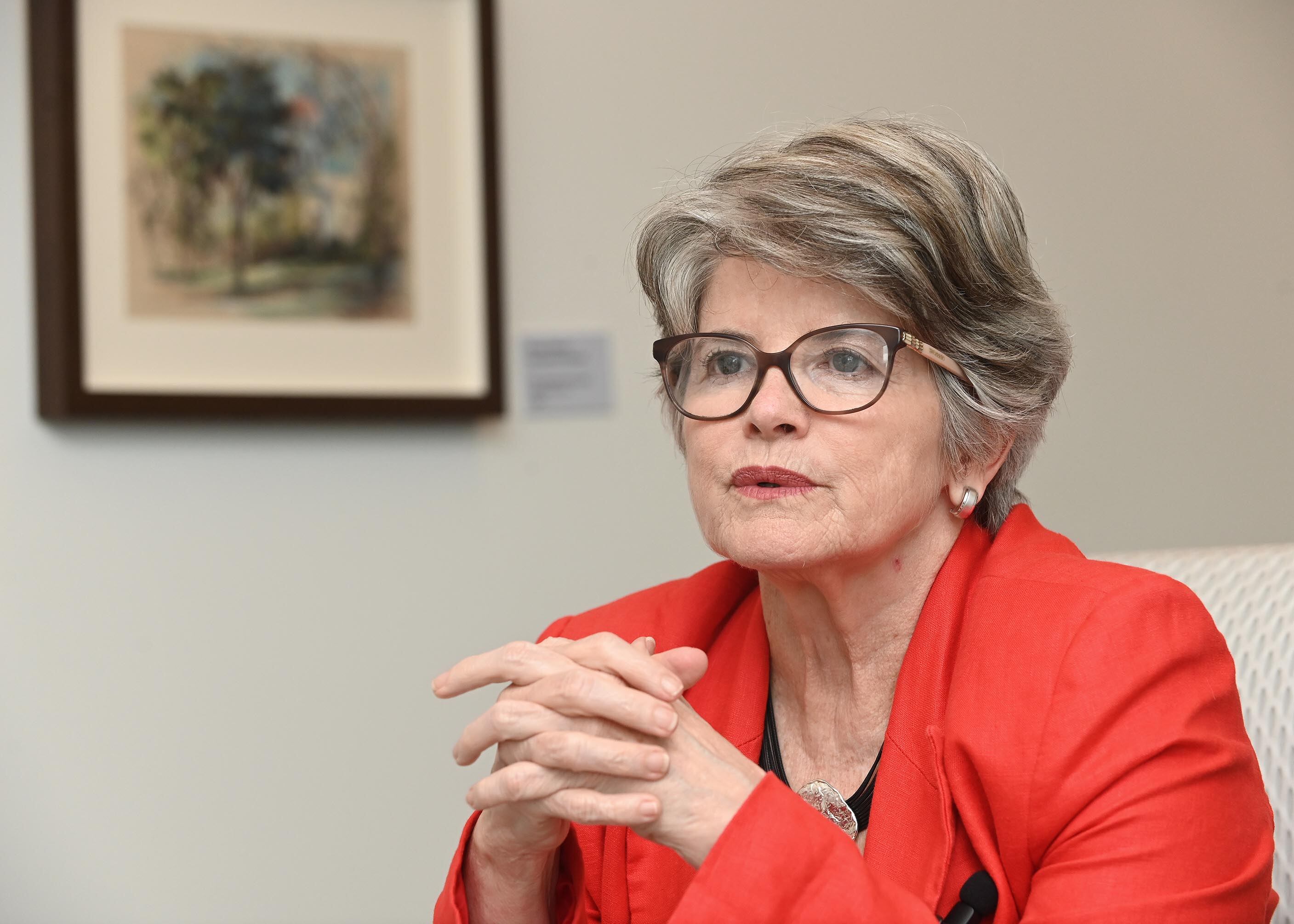 Rocío Aguilar, exsuperintendente de Pensiones, vestida con un saco rojo, habla en una entrevista. La exjerarca critica la postergación de la implementación de los fondos generacionales en el ROP.