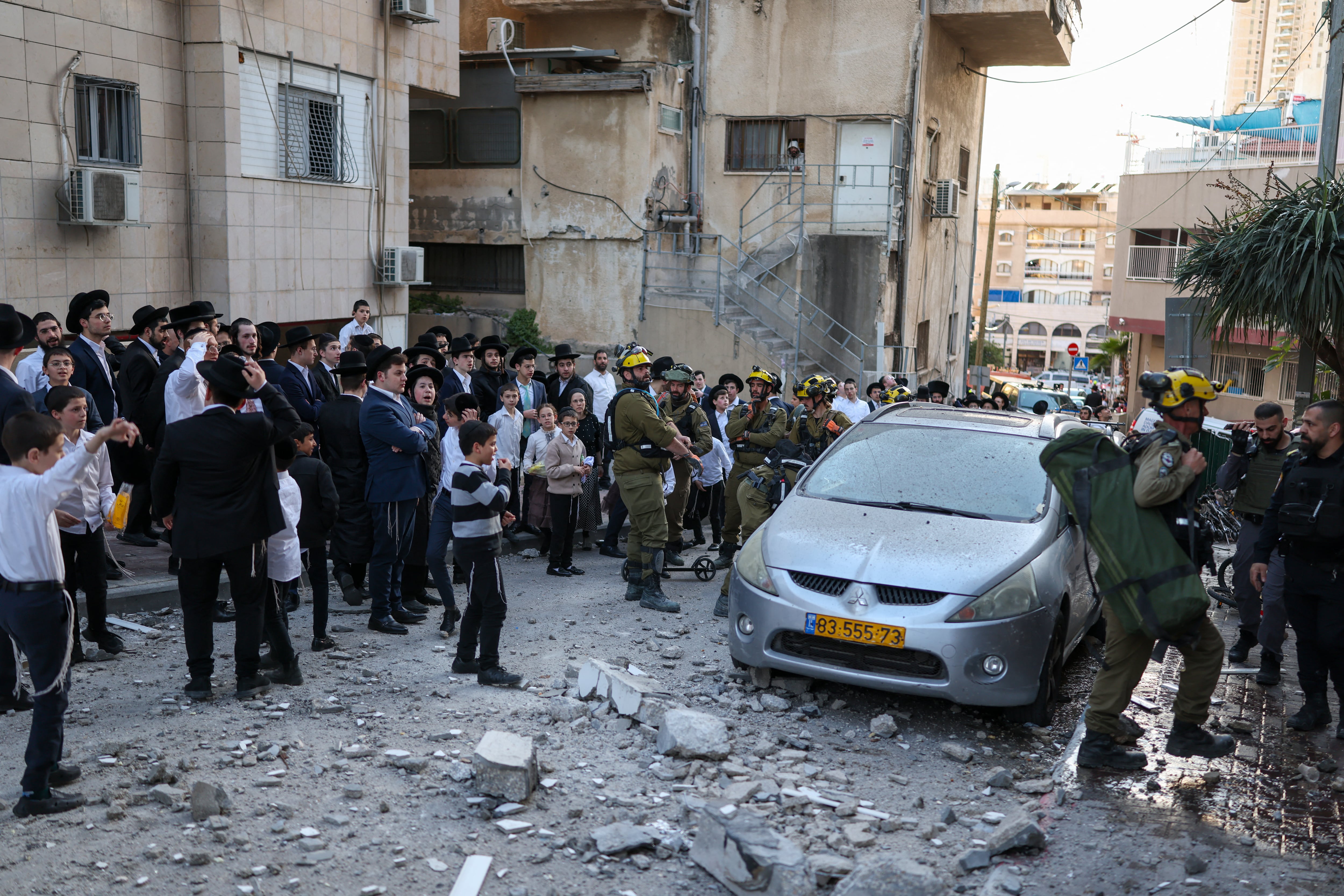 Israeli first responders arrive at a site where debris from a rocket interception fell in a neighbourhood on the outskirts of Tel Aviv on February 28, 2026. The United States and Israel launched strikes against Iran on February 28, with Israel's public broadcaster reporting that the Iranian supreme leader had been targeted, as the Islamic republic retaliated with barrages of missiles at Gulf states and Israel. (Photo by Ilia YEFIMOVICH / AFP)