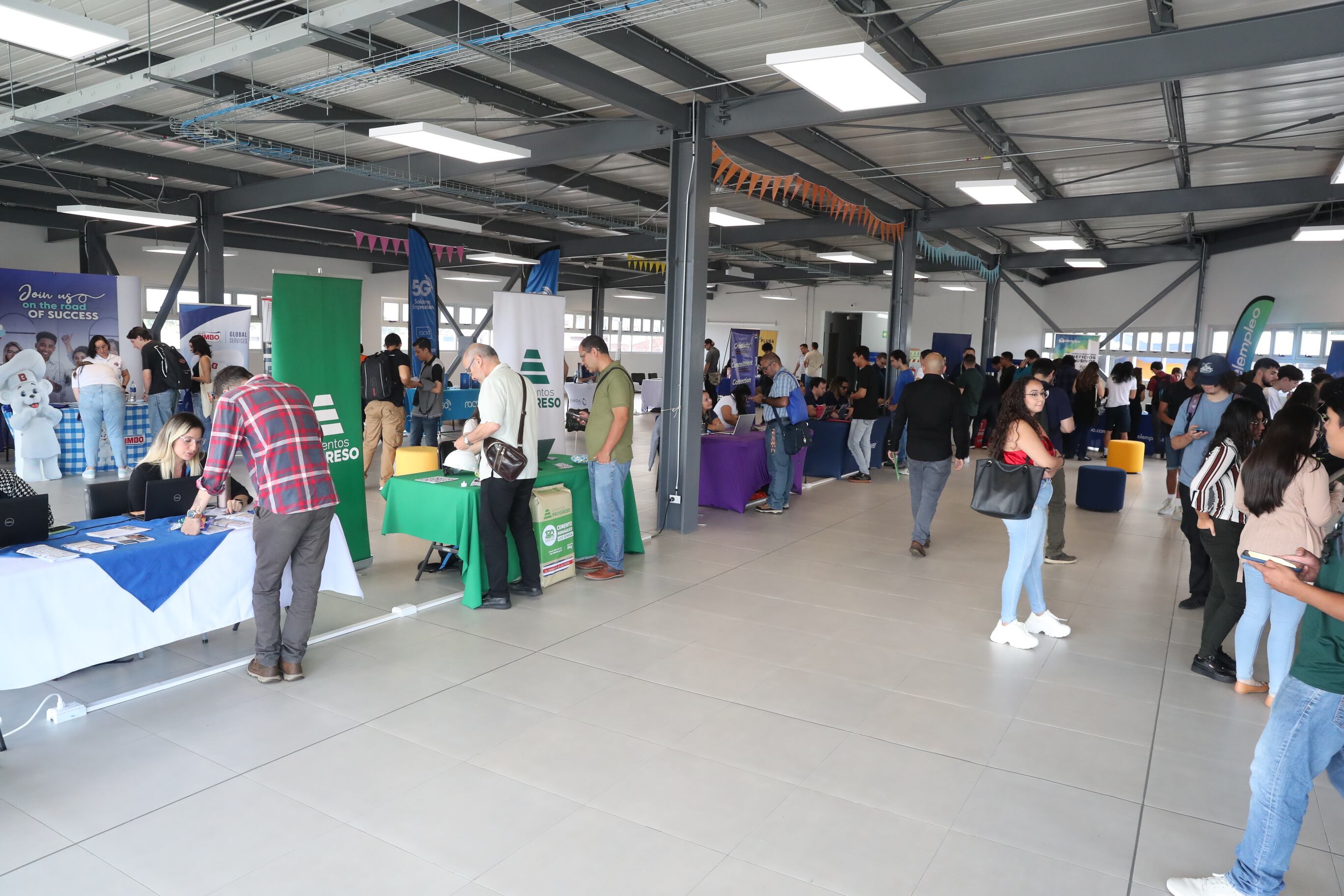 Toma general de una feria de empleo con varios puestos y gente.