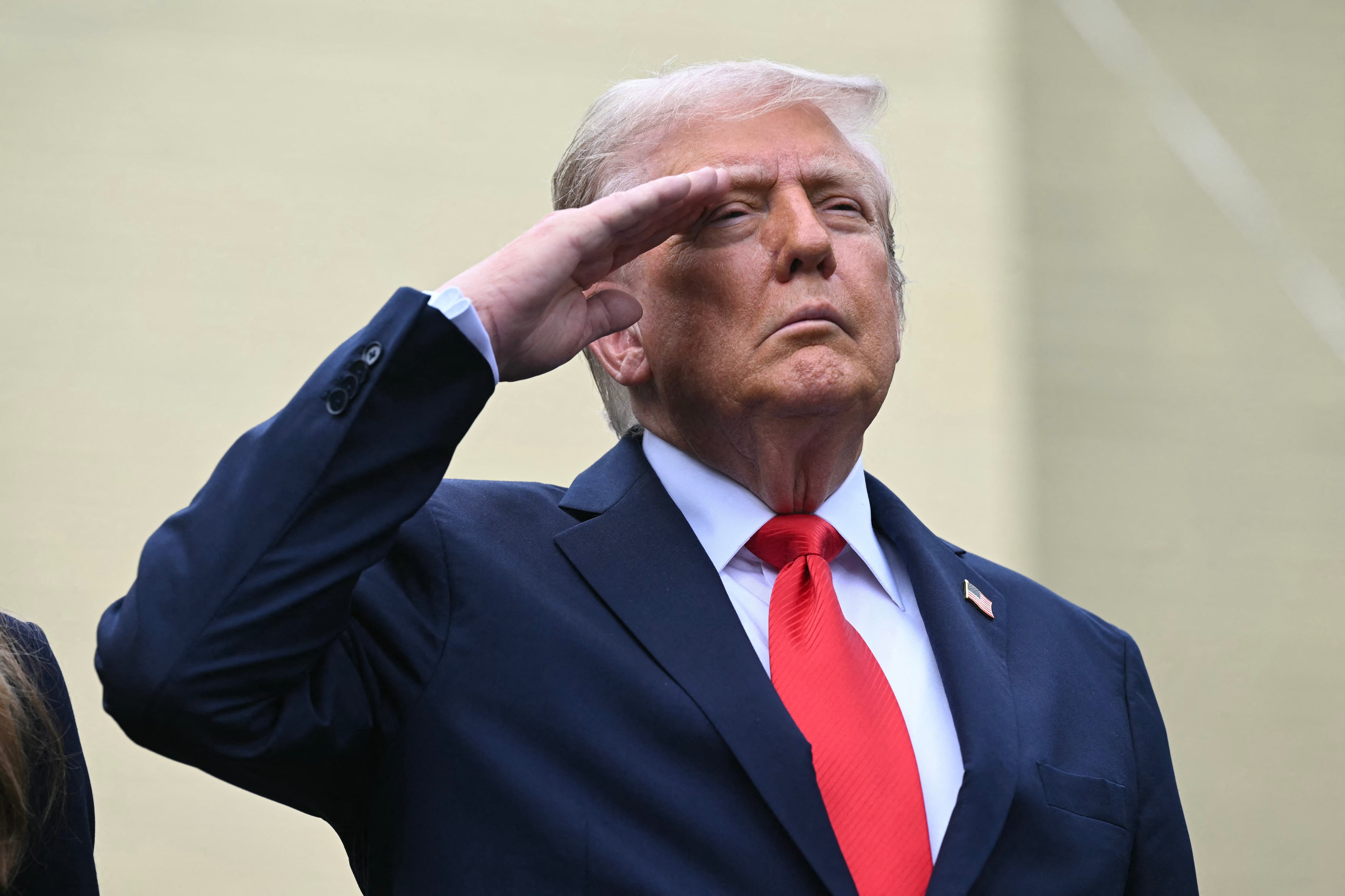 El presidente de Estados Unidos, Donald Trump, saluda mientras escucha el himno nacional durante la ceremonia de conmemoración del 11-S en el Memorial del Pentágono, en Washington.