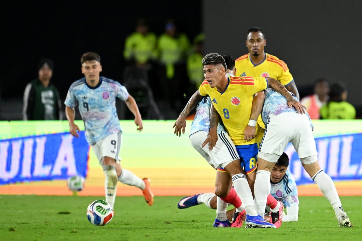 Jorge Carrascal, jugador de Colombia, pelea por el balón con los jugadores de Costa Rica, mientras atrás Andrey Soto ve desde el césped la acción.