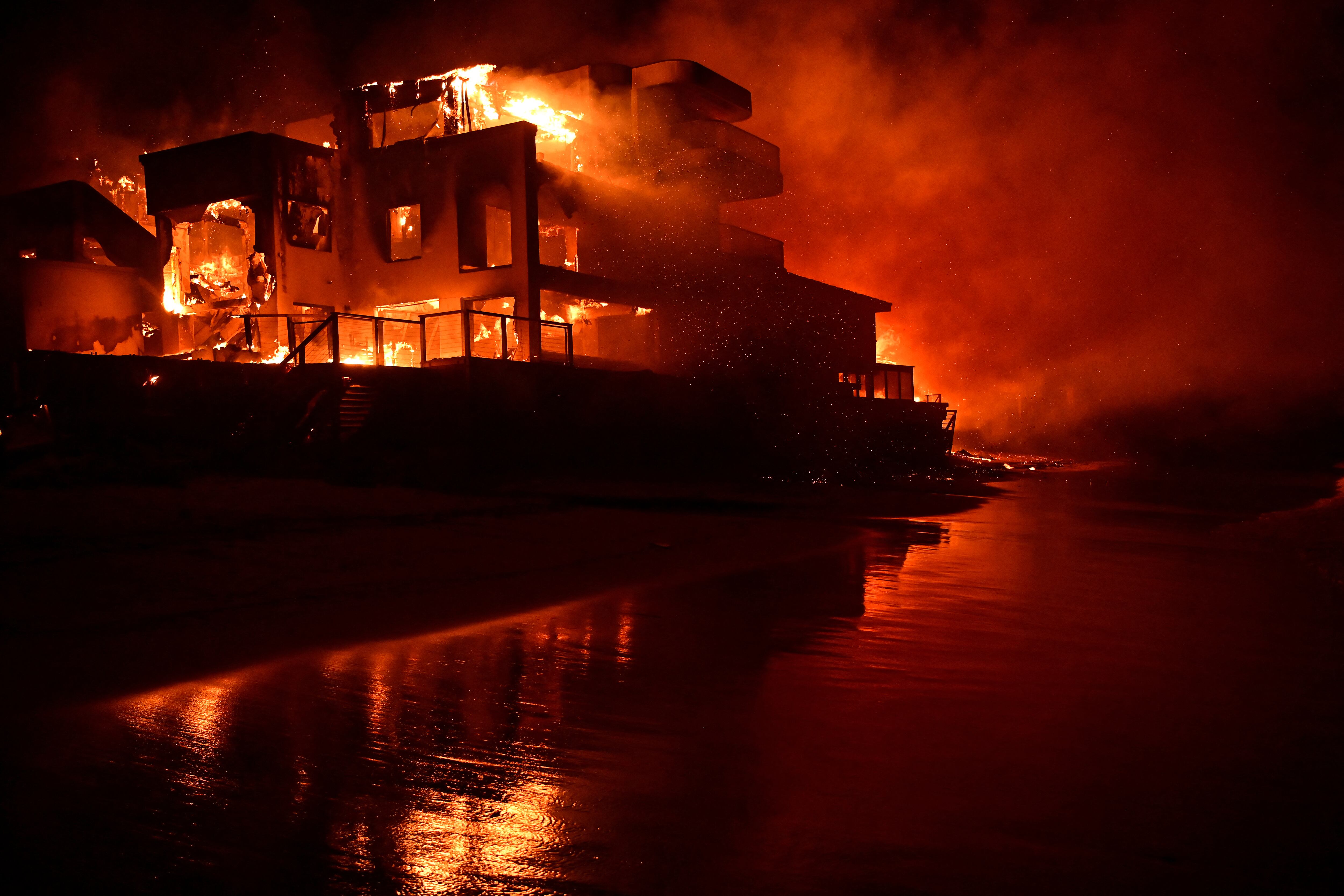Una casa de playa envuelta en llamas mientras el incendio Palisades arde a lo largo de la Pacific Coast Highway en Malibú, California.