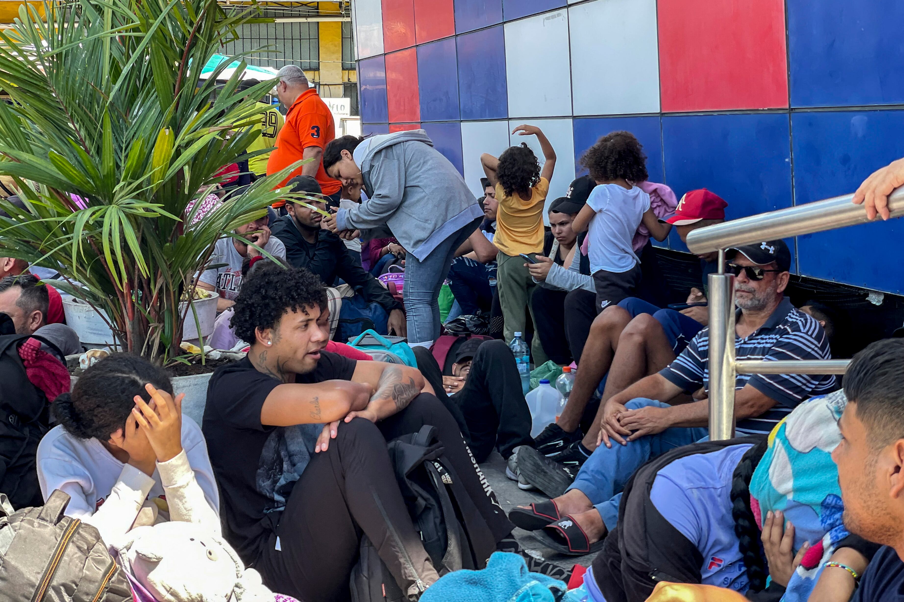 Venezuelan migrants are seen outside the immigration office as they wait for permission to enter Panama at Paso Canoas between the Panama and Costa Rica border on February 11, 2025. One hundred thousand migrants, stranded on the border between Costa Rica and Panama, are trying to return to Venezuela after failing in their attempt to reach the United States. (Photo by Paul MONTENEGRO / AFP)