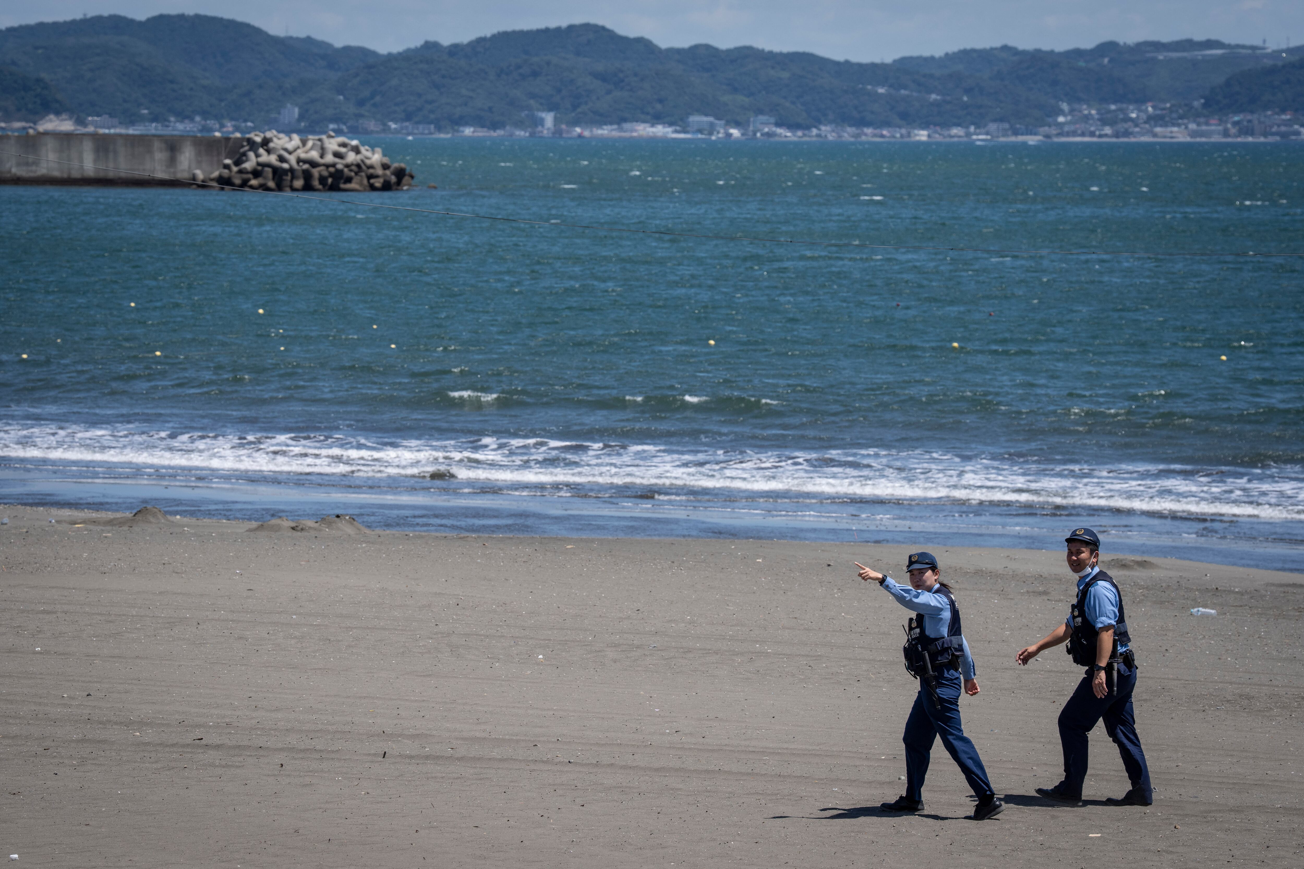 Agentes de policía piden a las personas evacuar una playa vacía debido a una alerta de tsunami en la ciudad de Fujisawa, prefectura de Kanagawa, el 30 de julio de 2025.
