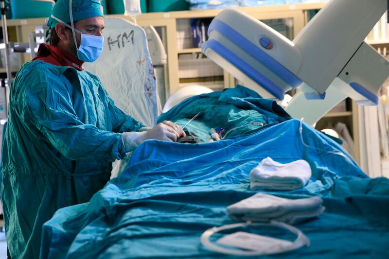 Quirófano: médico vestido de verde realiza procedimiento coronario.