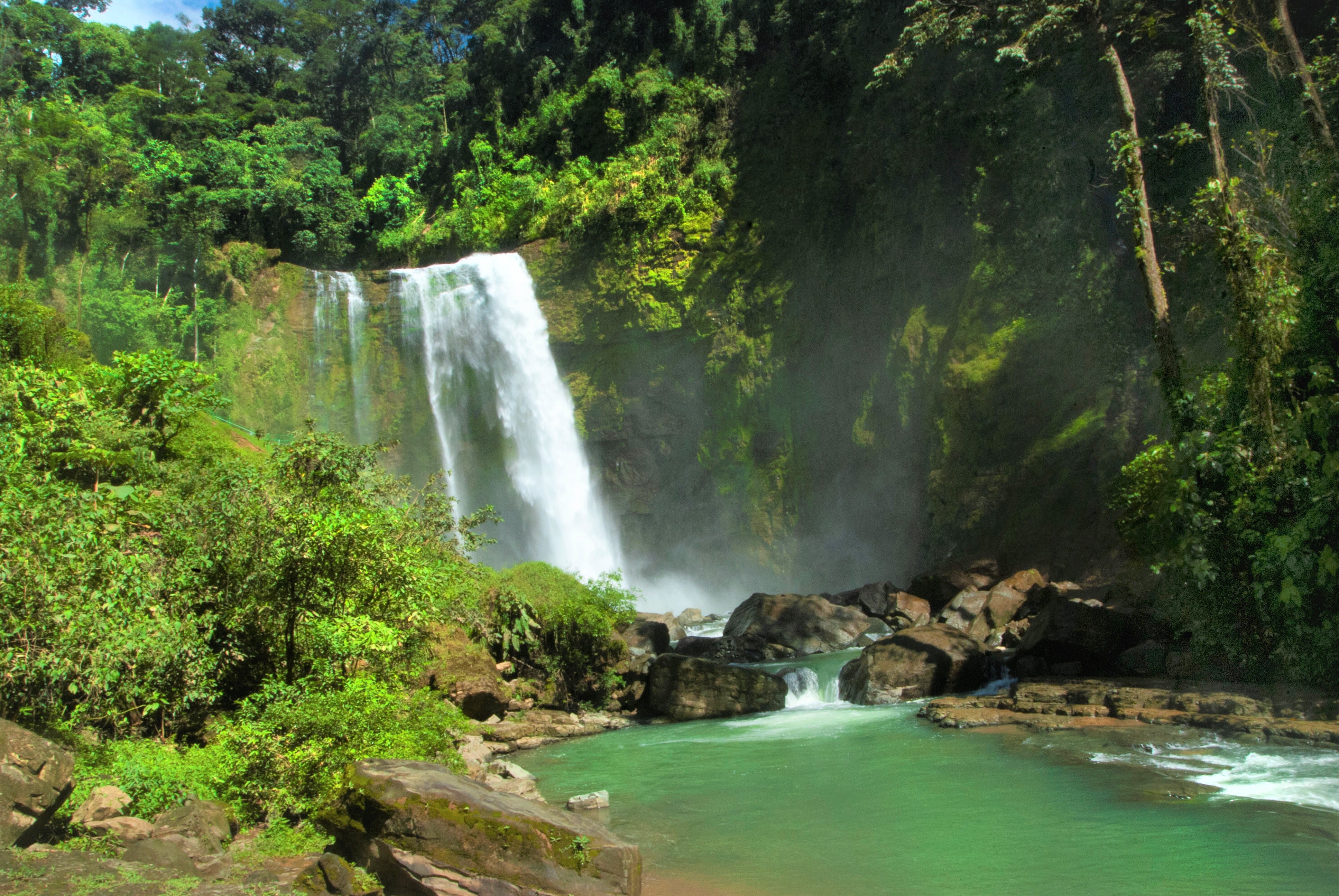Descubra la majestuosidad de una catarata y su sendero en un entorno fascinante.