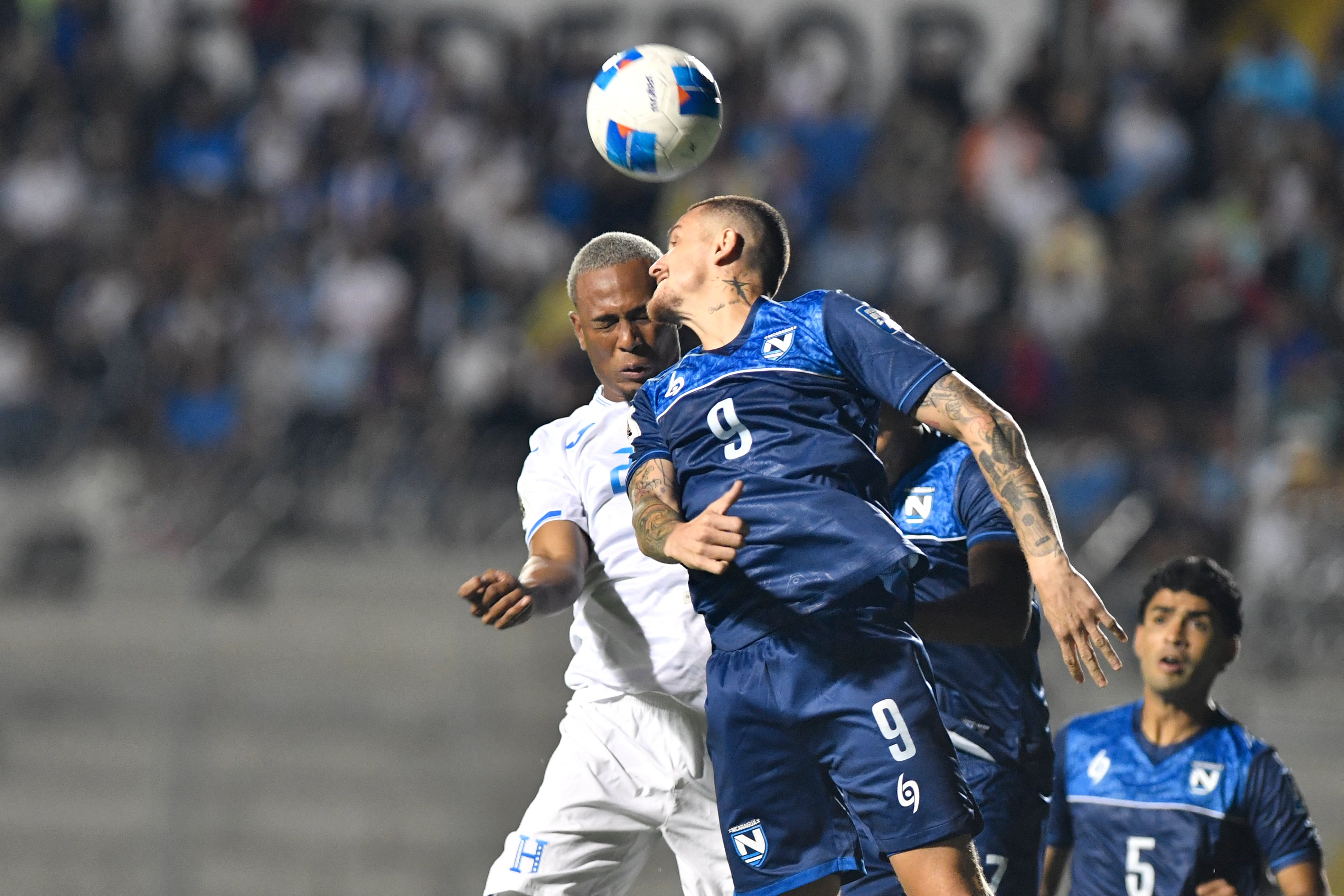 Deybi Flores de Honduras salta con Jaime Moreno de Nicaragua, en el Estadio Nacional Chelato Uclés, por la eliminatoria rumbo al Mundial 2026.