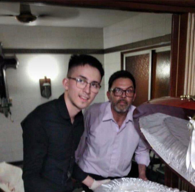 Hombres se fotografían junto a ferétro de Maradona