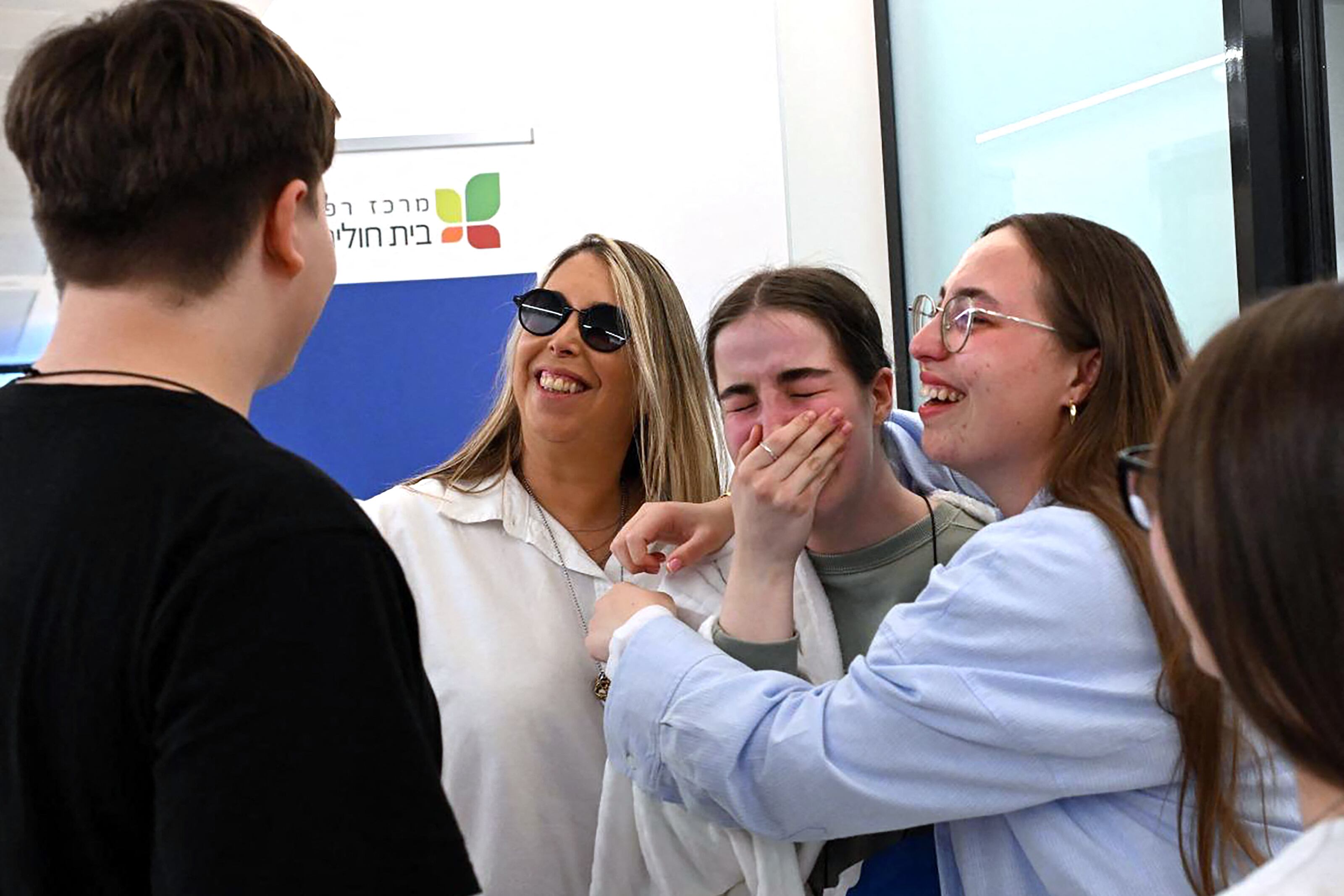 Esta fotografía difundida por la oficina de prensa del gobierno israelí (GPO) muestra a la rehén israelí liberada Agam Berger (centro-derecha) siendo recibida por su familia en el hospital Beilinson en Petah Tikva, cerca de Tel Aviv, después de su liberación por Hamás en la Franja de Gaza.