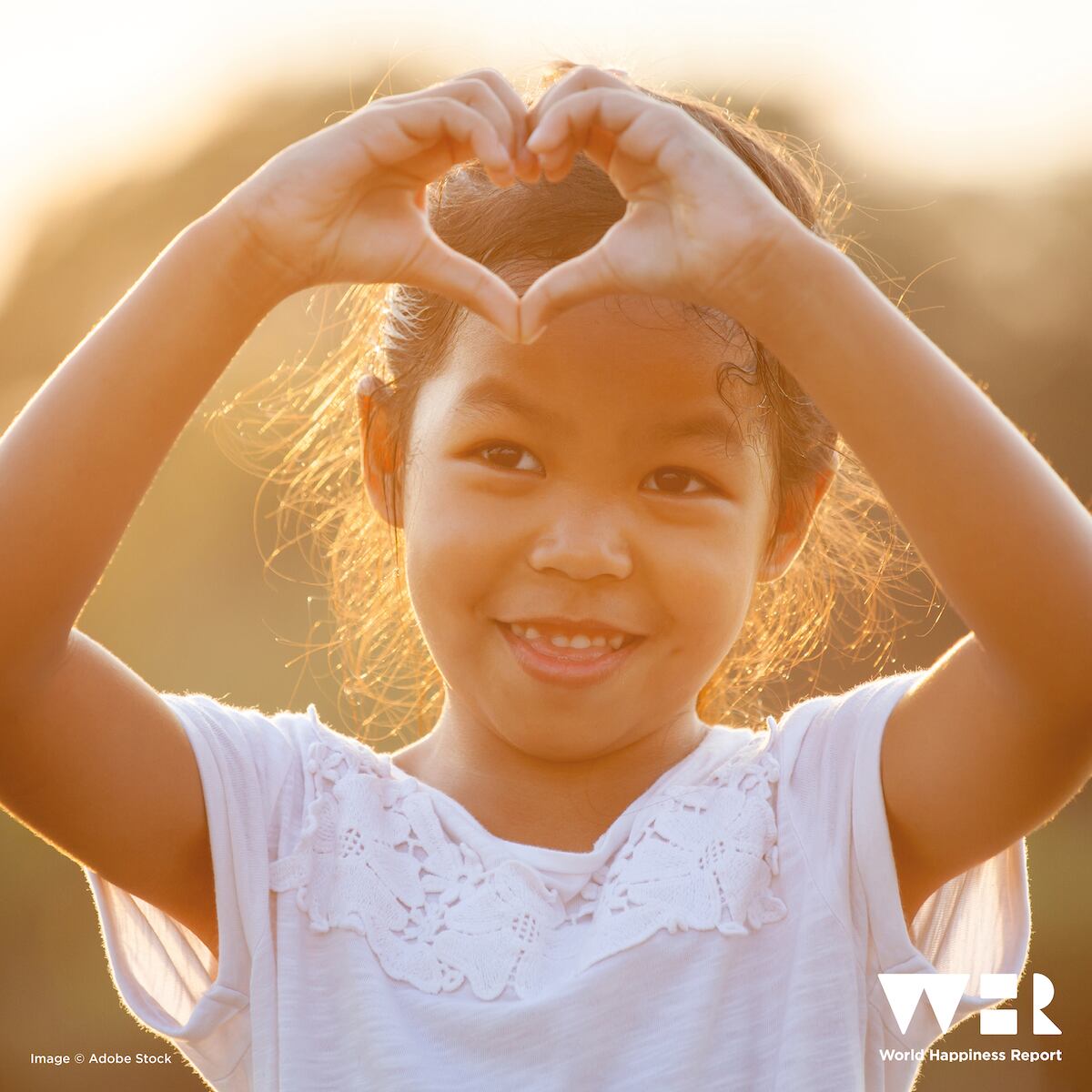 Una niña haciendo un corazón con sus manos.