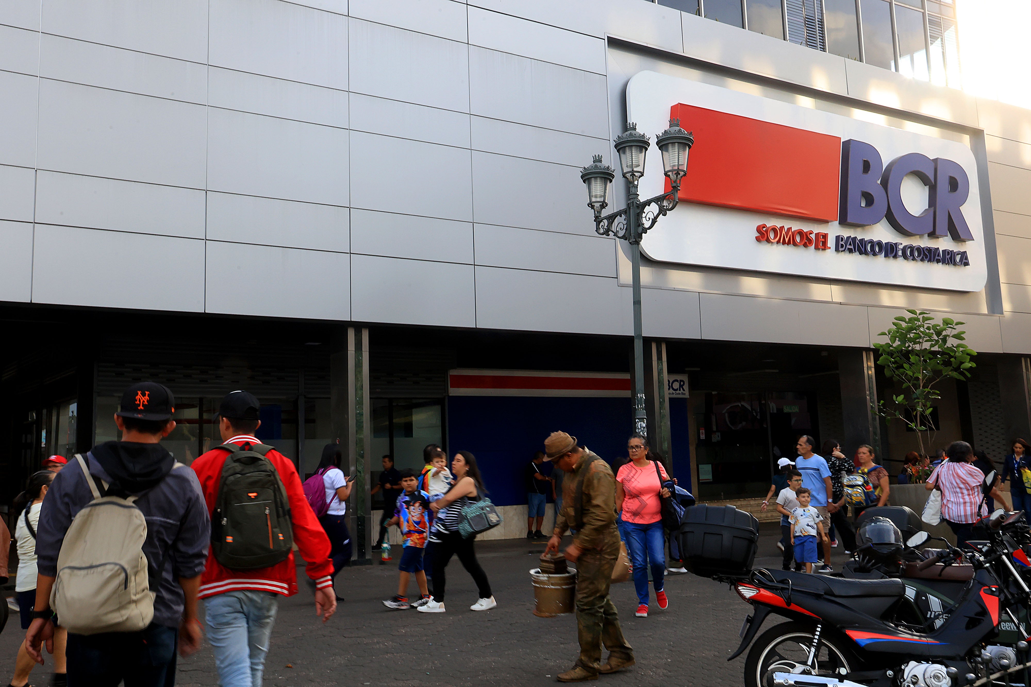 Vista frontal del edificio central del Banco de Costa Rica (BCR) en San José, con personas caminando frente al edificio.