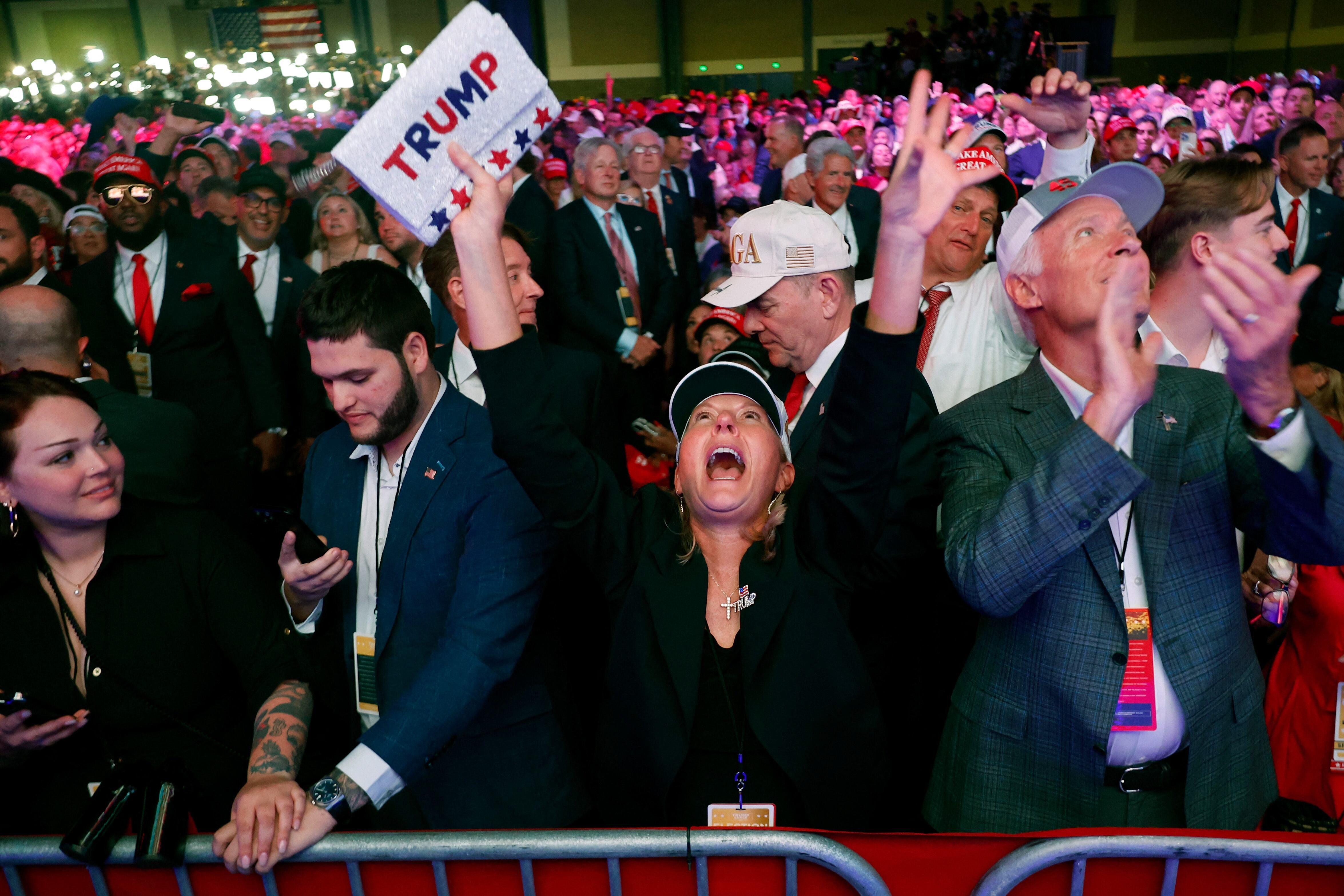 Seguidores de Donald Trump celebran y reaccionan mientras observan los resultados en una fiesta de seguimiento de la noche electoral de las Elecciones en Estados Unidos del candidato republicano a la presidencia, el expresidente Donald Trump, en el Centro de Convenciones de Palm Beach, en Florida