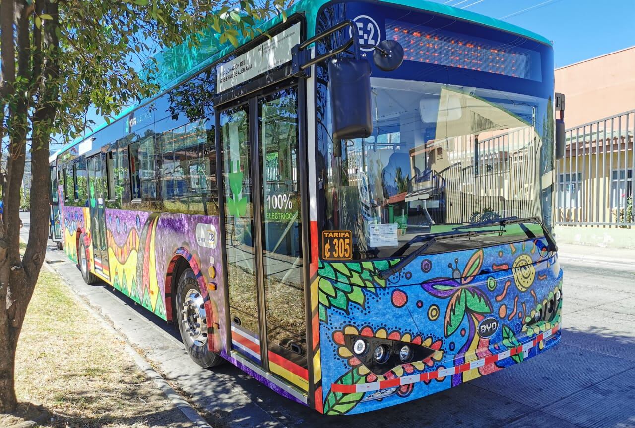 Autobús eléctrico con diseño colorido estacionado en una calle de Costa Rica, promoviendo la movilidad sostenible.