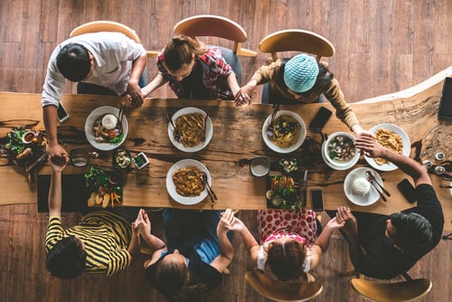 Vista aérea de una familia unida en torno a una mesa, simbolizando los valores de fe, familia y educación en la construcción de una sociedad próspera.