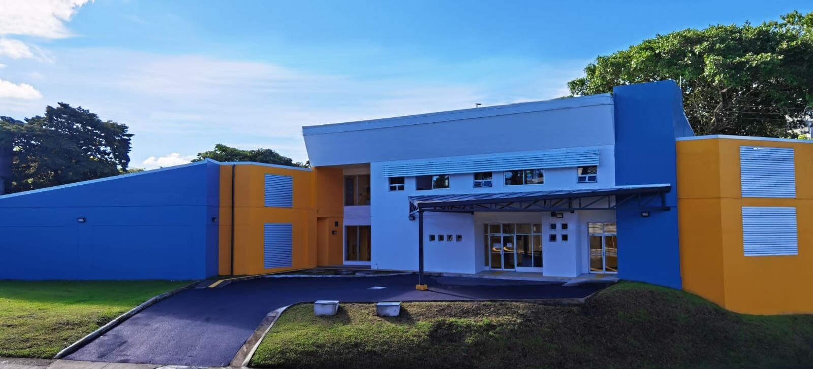 Edificio de colores llamativos, amarillo y celeste, de una sola planta.