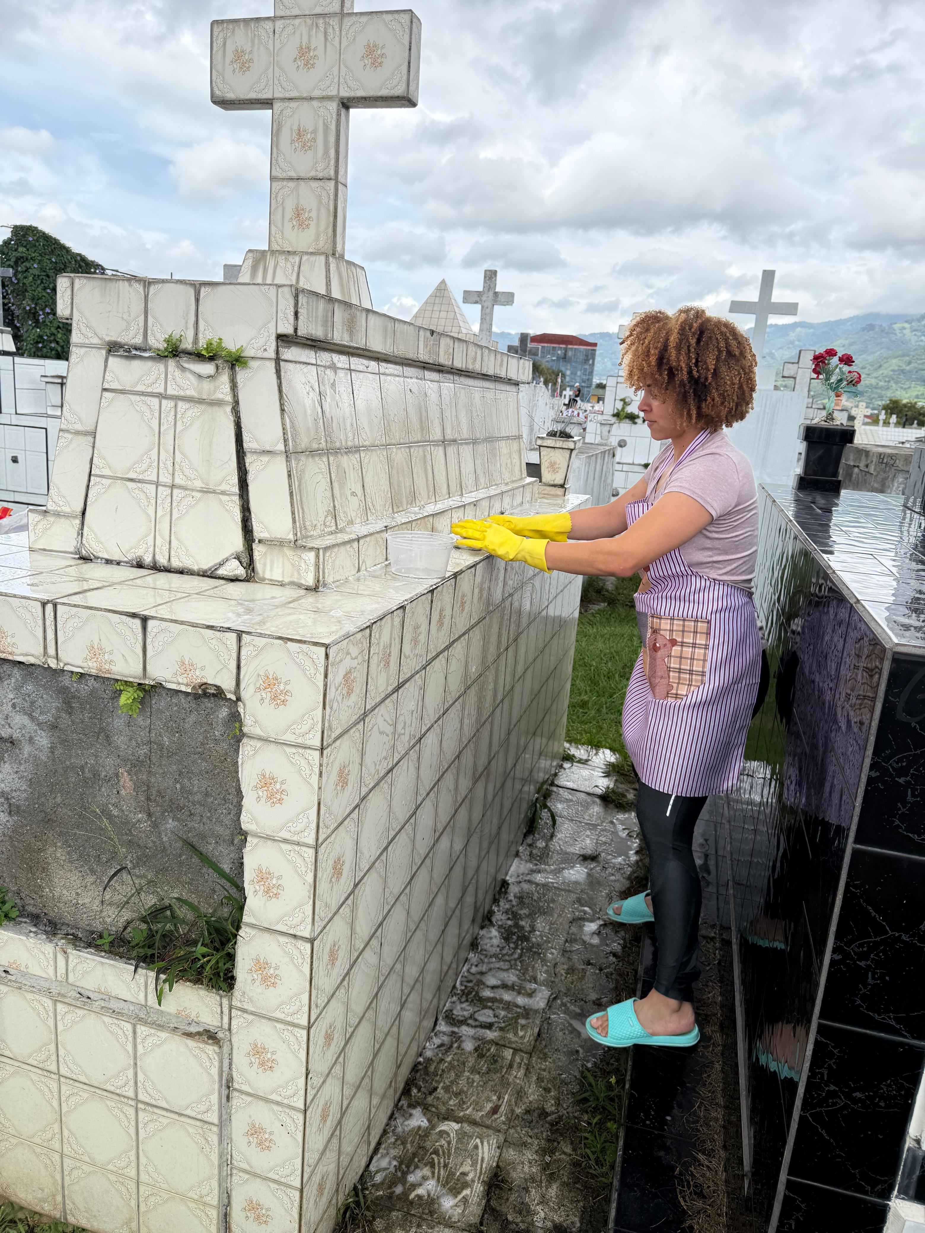El sábado 15 de agosto del 2026, Día de las Madres, realizamos un recorrido por tres cementerios en San José: el Obreros, el General y el Municipal de Desamparados. En la foto, Natalia Grant lava la tumba de su abuelita.
