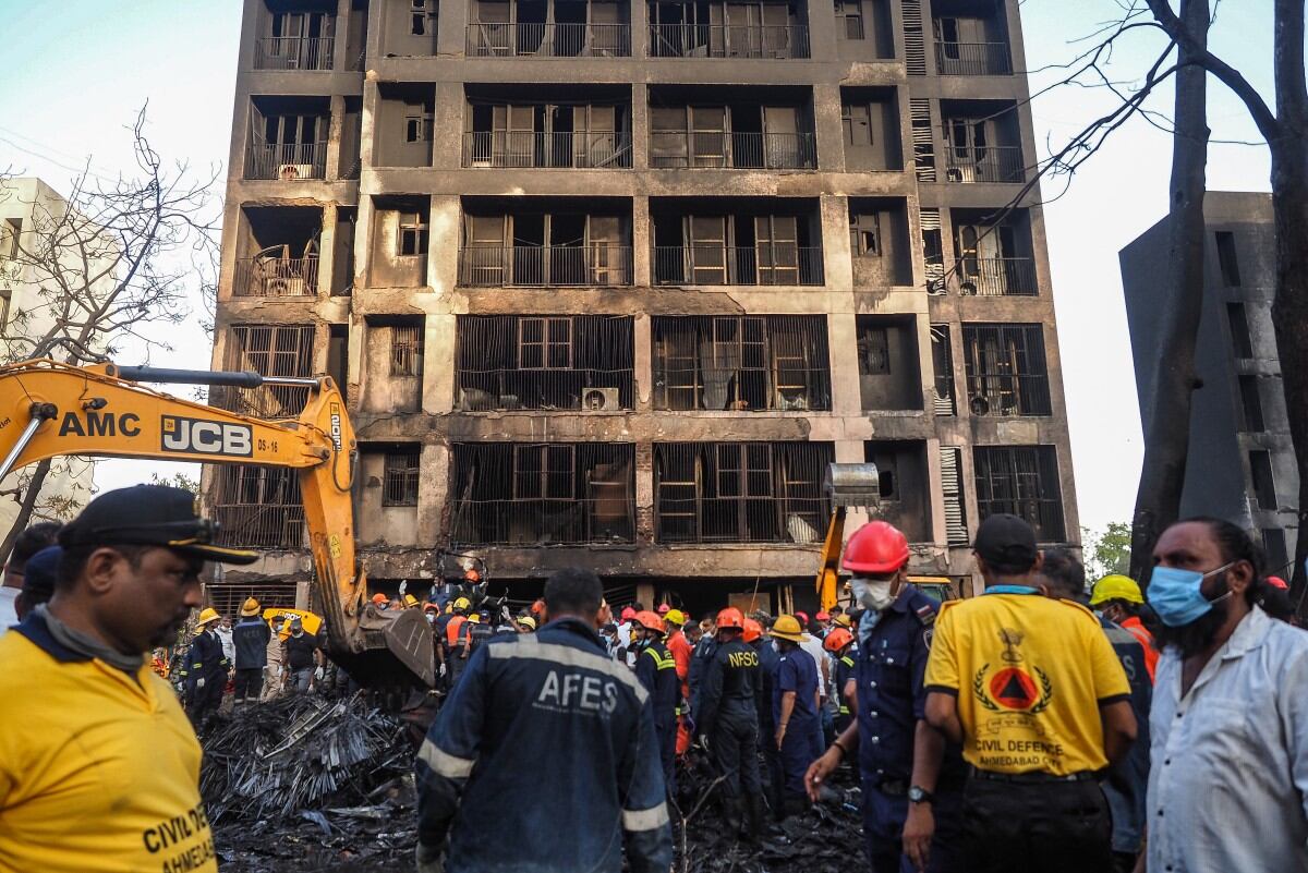 Rescue officials work at the site where Air India flight 171 crashed in a residential area near the airport in Ahmedabad on June 12, 2025. A London-bound passenger plane crashed in the Indian city of Ahmedabad on Thursday and all 242 people on board were believed killed, with the jet smashing into buildings housing doctors and their families. (Photo by Sam PANTHAKY / AFP)