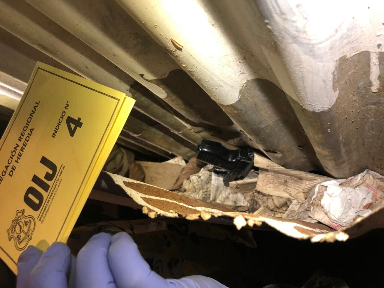 Un arma de fuego y drogas son parte de lo hallado por el OIJ en el allanamiento de este jueves en El Erizo, donde cayeron sospechosos de un homicidio. Foto: Cortesía OIJ.