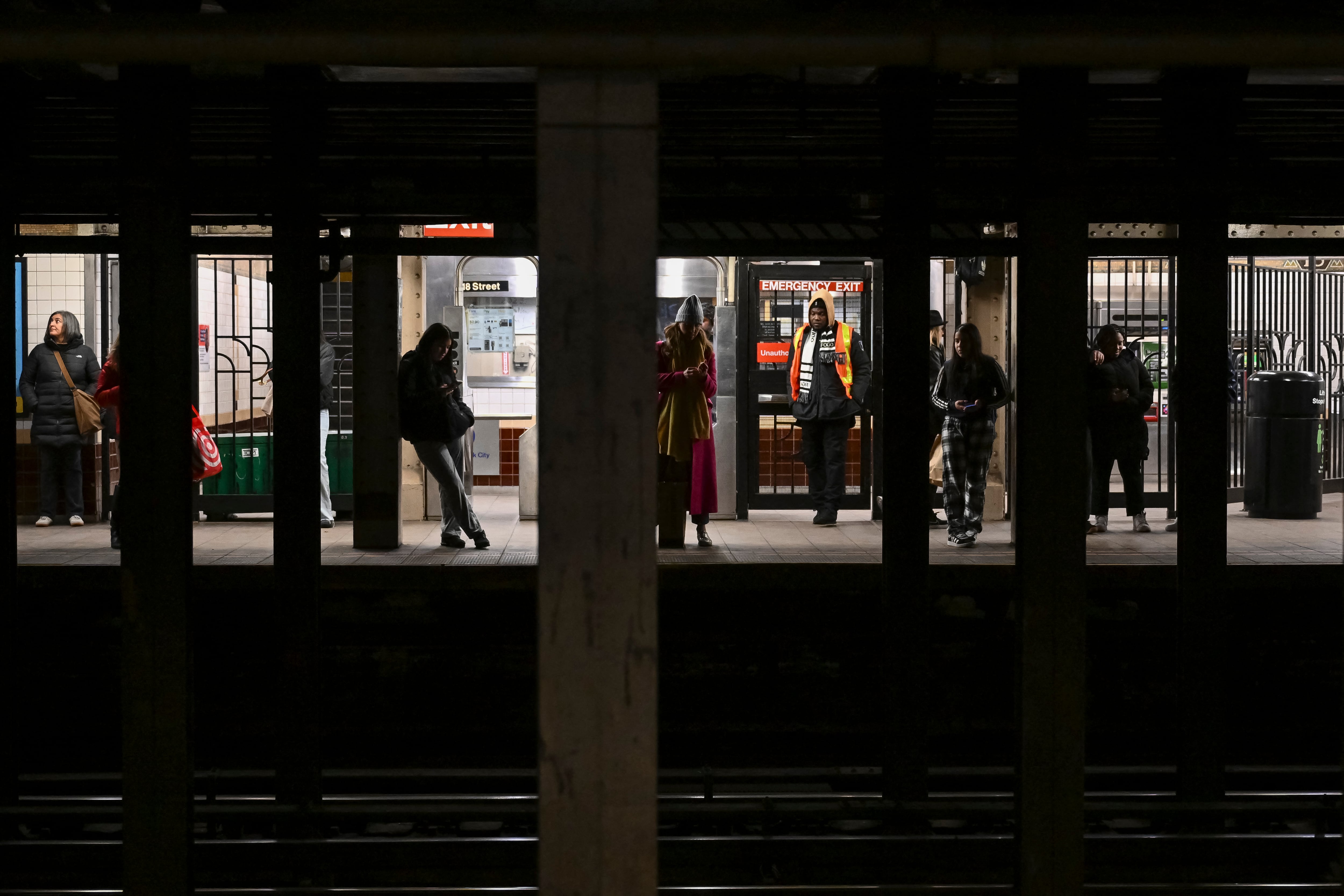 People stand on a subway platform in New York City on February 4, 2025. Joseph Lynskey was quietly waiting for a New York subway train on New Year's Eve when he was pushed from behind onto the tracks as a train pulled into the station. "I knew instantly... that somebody had pushed me and tried to kill me," the music producer told AFP. (Photo by ANGELA WEISS / AFP)