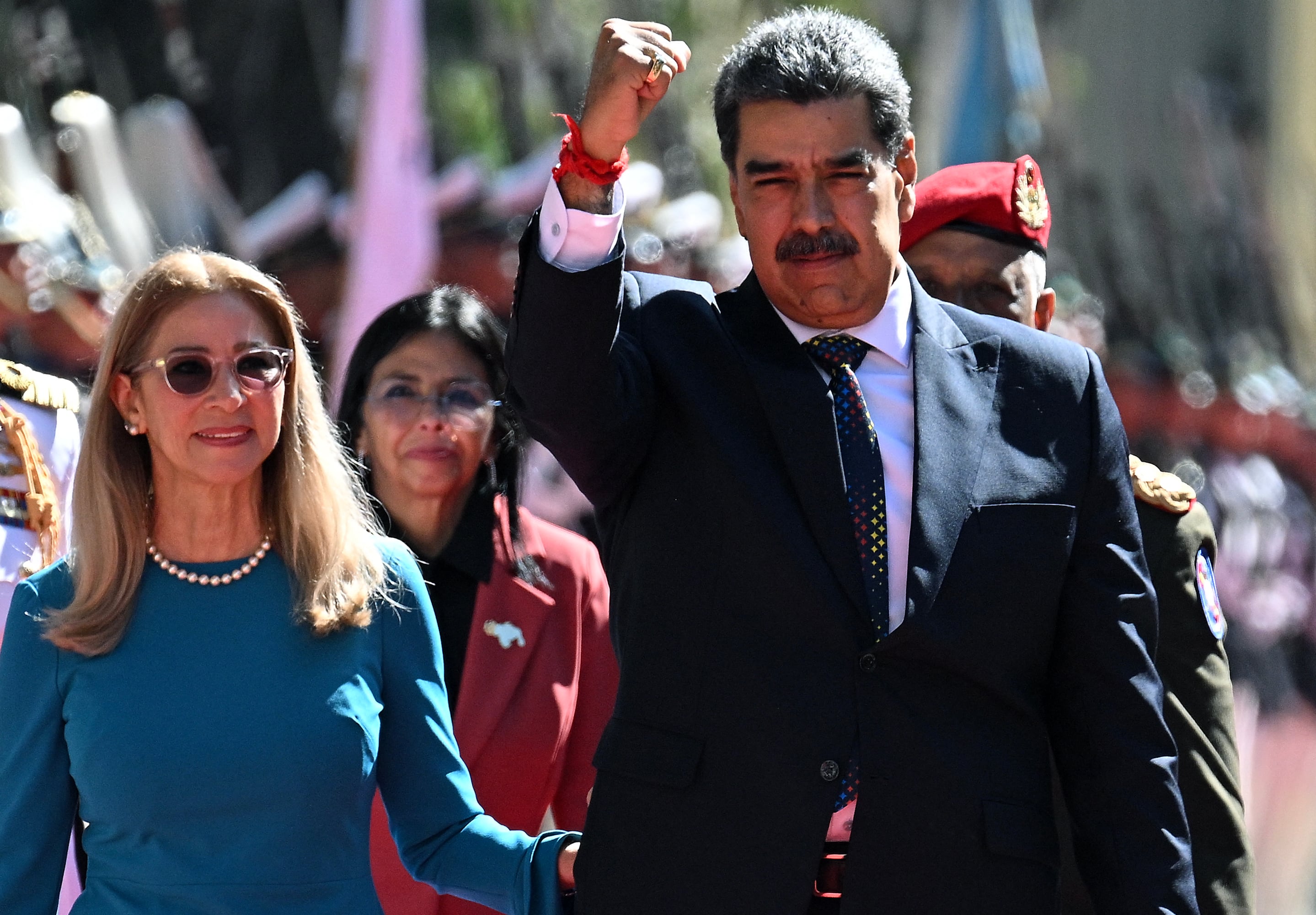 Nicolás Maduro levanta el puño junto a Cilia Flores durante su llegada al Capitolio para la investidura presidencial en Caracas.