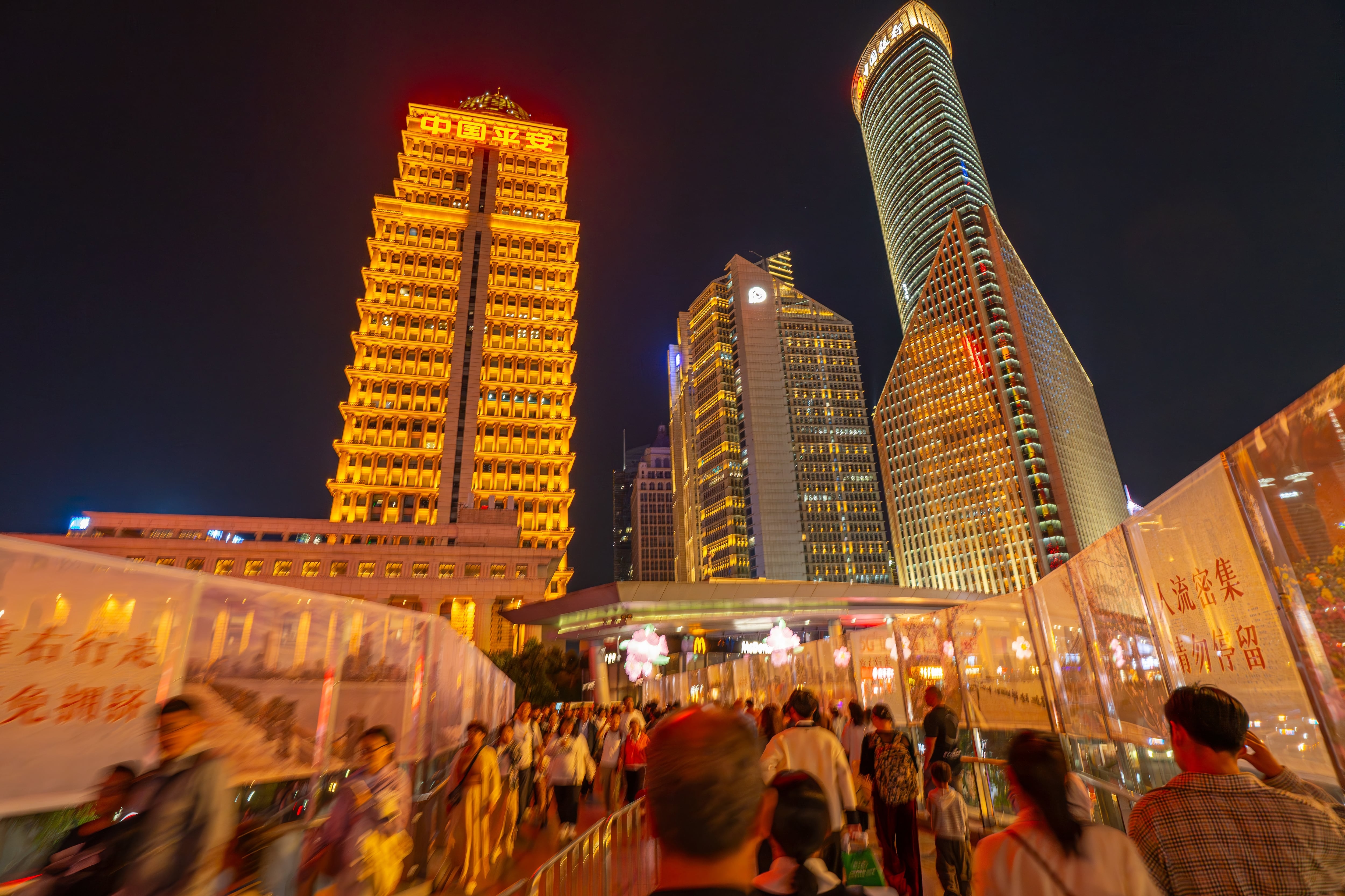 Shanghai, China - Octubre de 2024: Personas caminan a lo largo de una pasarela elevada con edificios al frente. Distrito financiero de Lujiazui.
