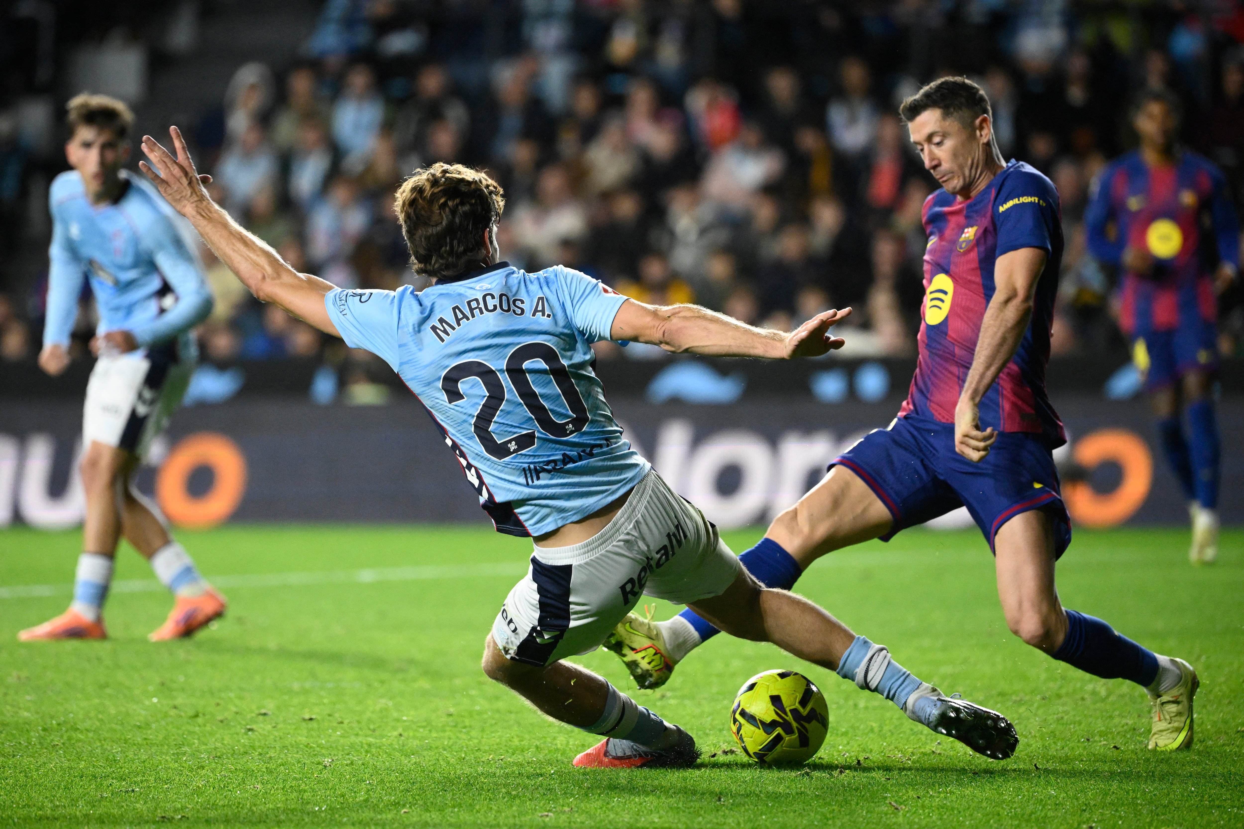 El defensor del Celta Marcos Alonso Mendoza disputa el balón con el delantero del Barcelona Robert Lewandowski durante el partido en Balaídos por la Liga Española.