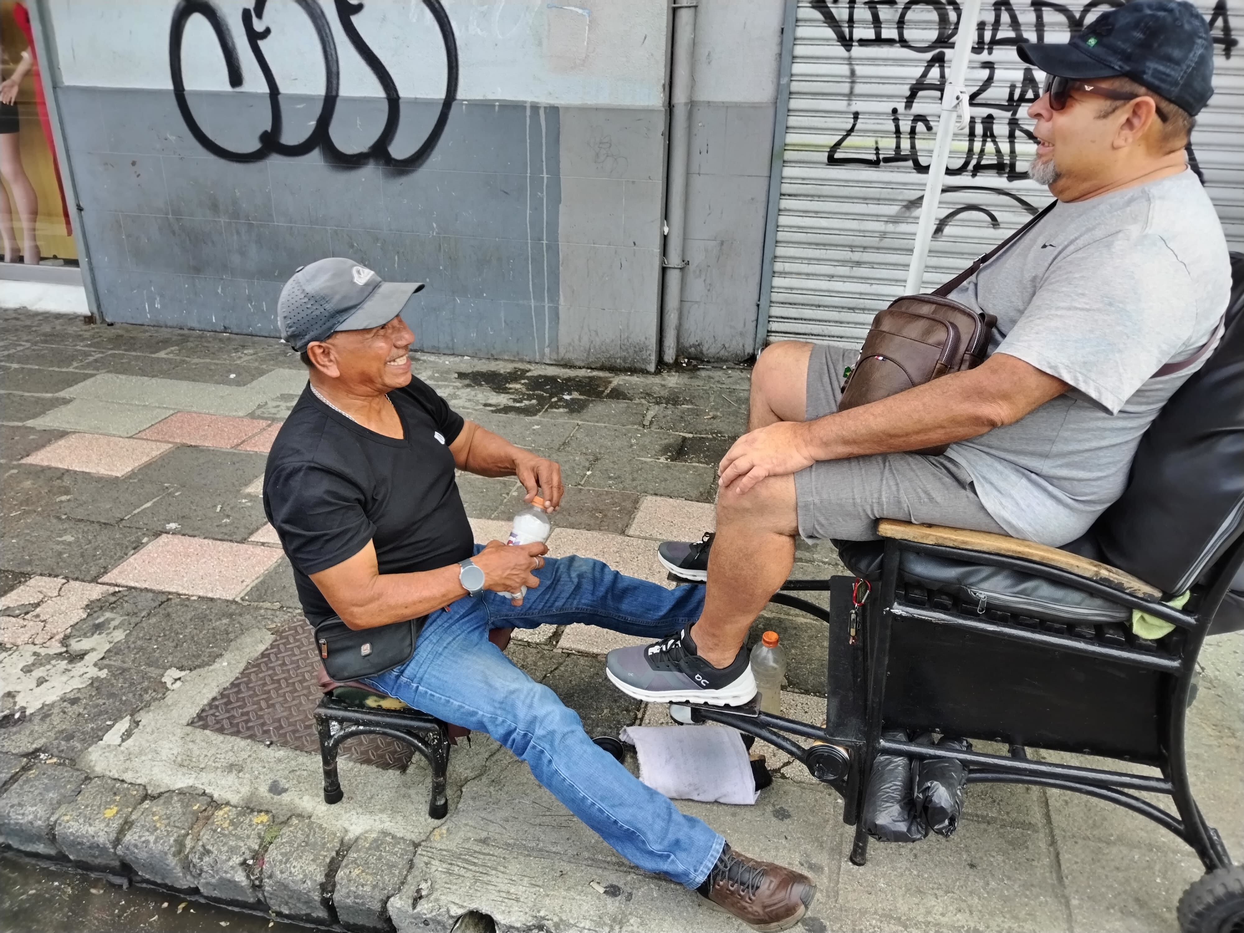 Ernesto Julián Navarro González acaba de cumplir 70 años y desde los 10 empezó en el noble oficio de limpiabotas, el cual, según nos dice con dolor, “está muy cerca de desaparecer porque a los jóvenes de ahora no les interesa”. En la foto le limpia las tenis a don Alberto Gutiérrez.