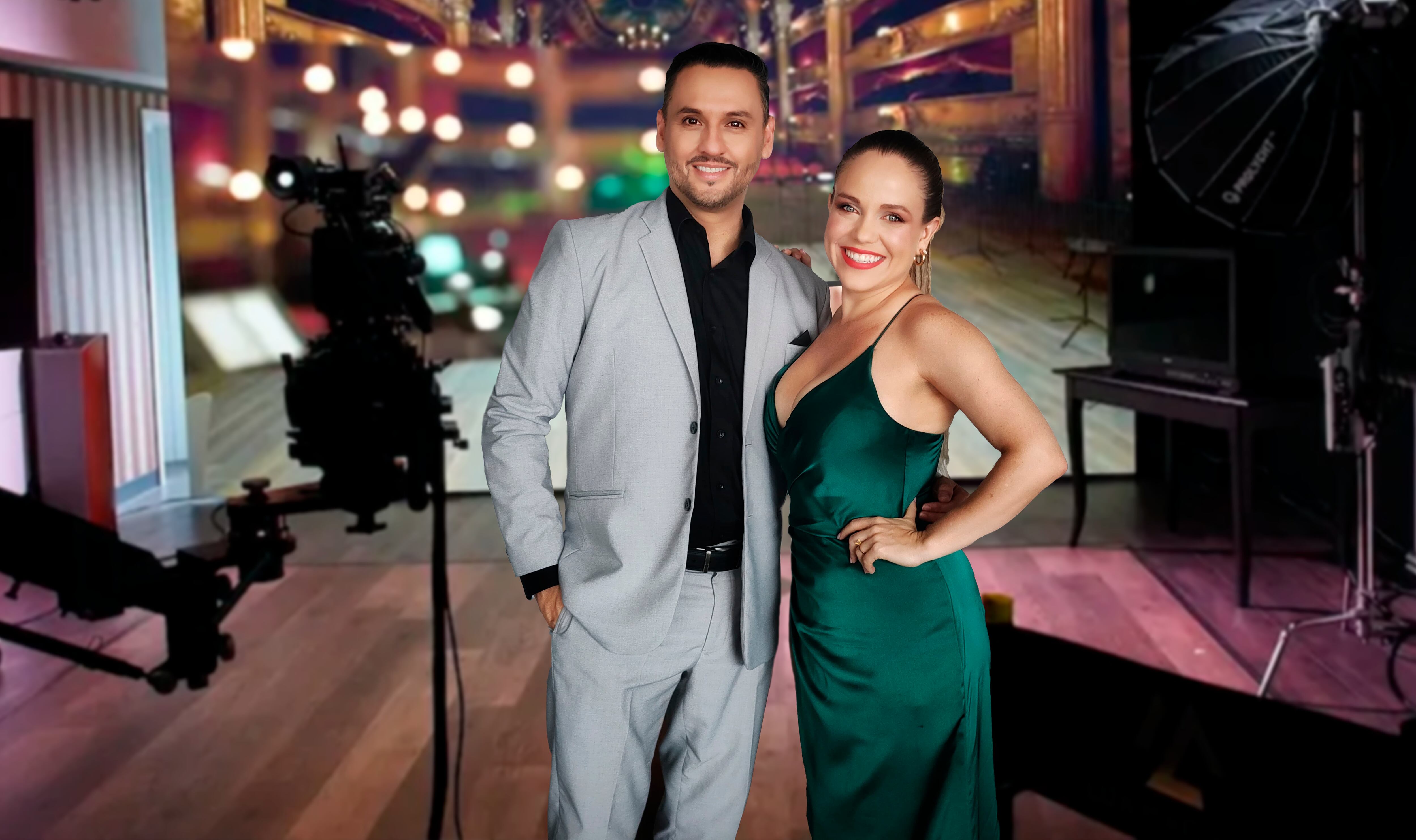 Walter Campos abrazado a Sofía Chaverri.  Él usa un traje gris y camisa negra, ella un vestido con escote de color verde.