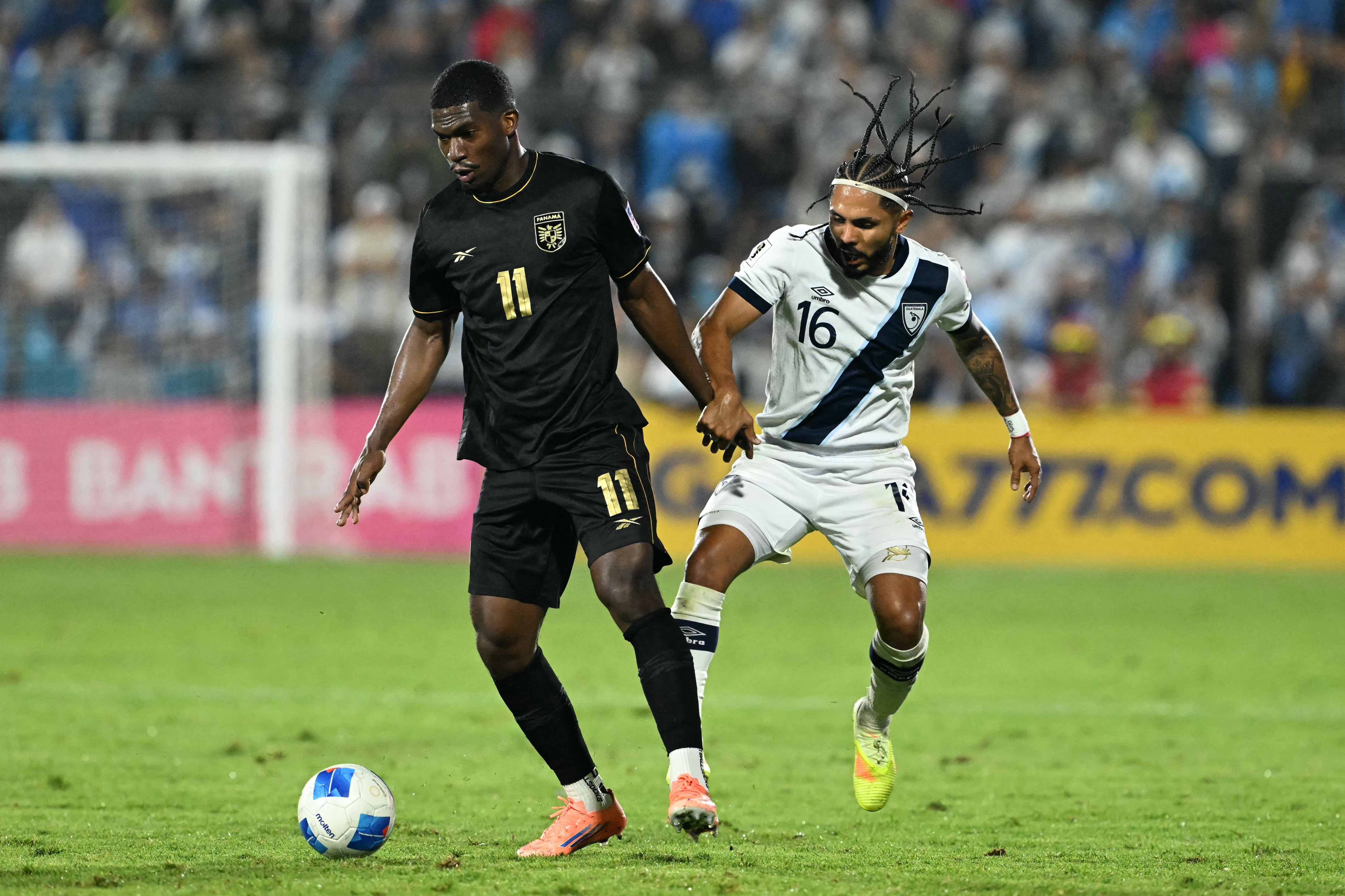 El delantero de Panamá Azarías Londoño disputa el balón con José Morales de Guatemala, en el compromiso por las eliminatorias de Concacaf rumbo al Mundial 2026.