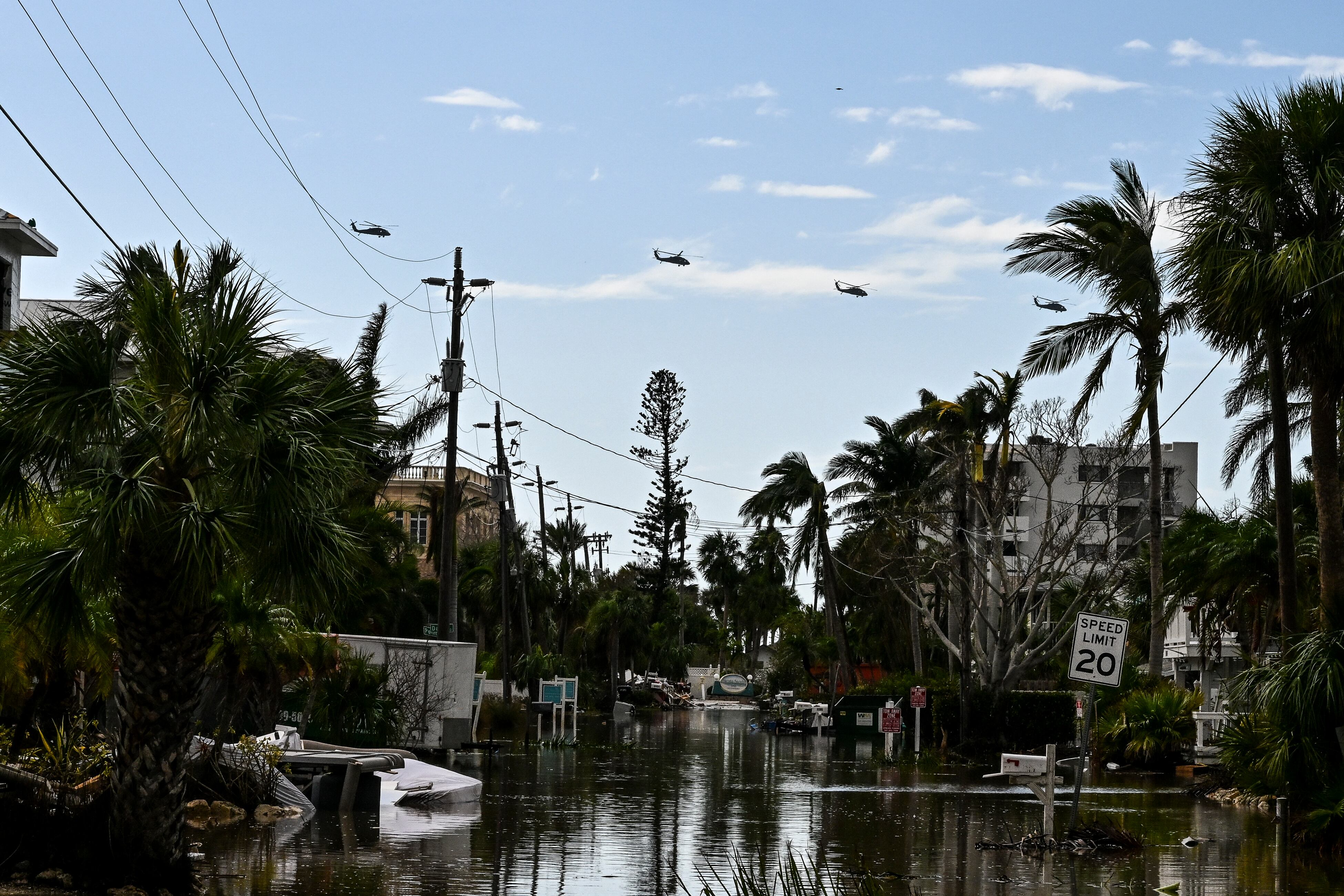 Helicópteros militares sobrevuelan Siesta Key tras el huracán Milton que dejó graves inundaciones. Foto por CHANDAN KHANNA / AFP