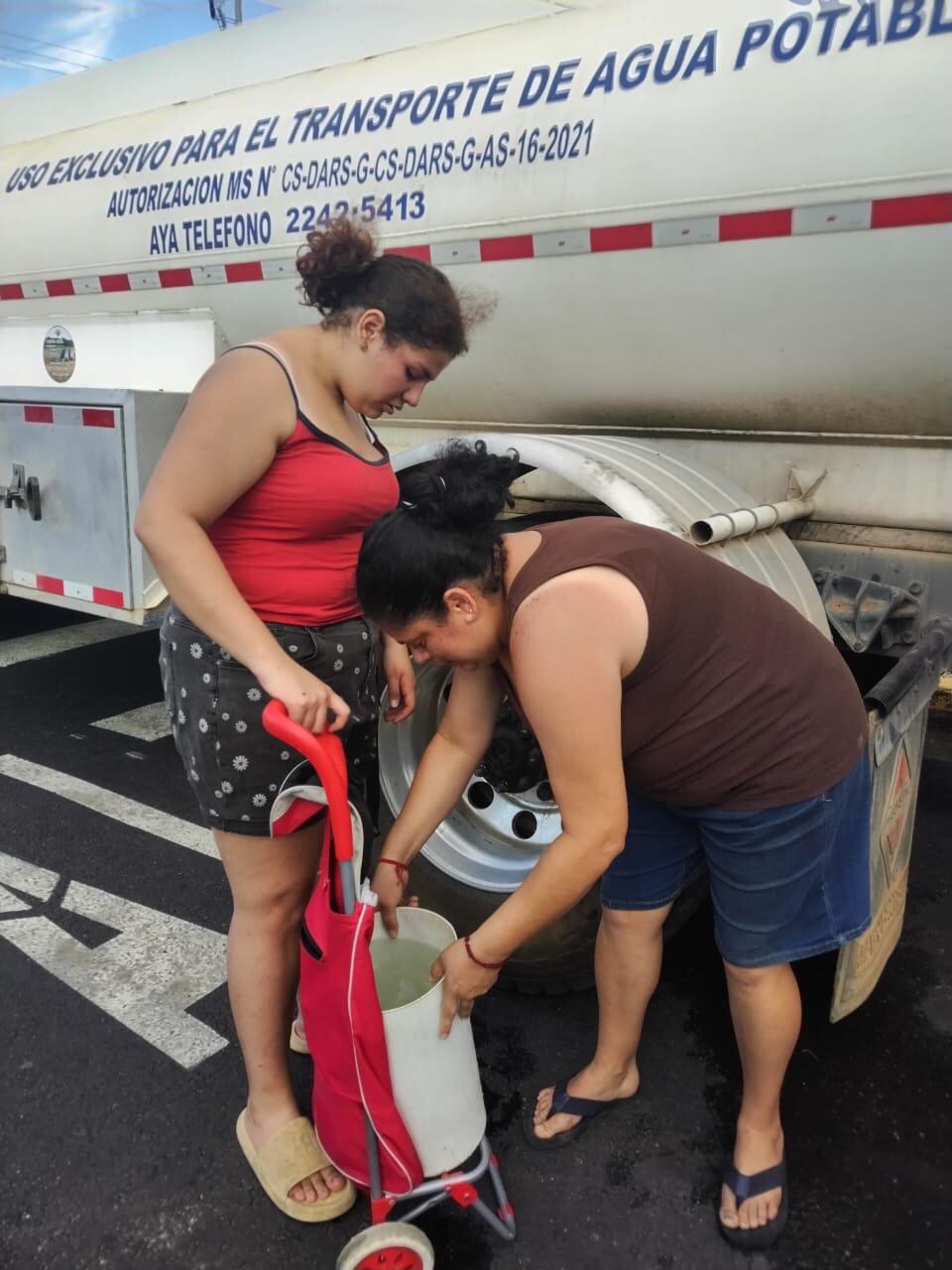 Los vecinos de Hatillo salen corriendo para lograr recoger un poco de agua.