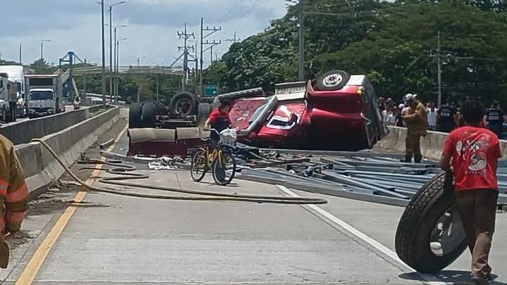 El conductor de un tráiler se salvó de lo que pudo haber sido una tragedia luego de que el vehículo de carga pesada que conducía terminara volcado este lunes sobre el río Cañas, en la Ruta 1. Foto: Bomberos