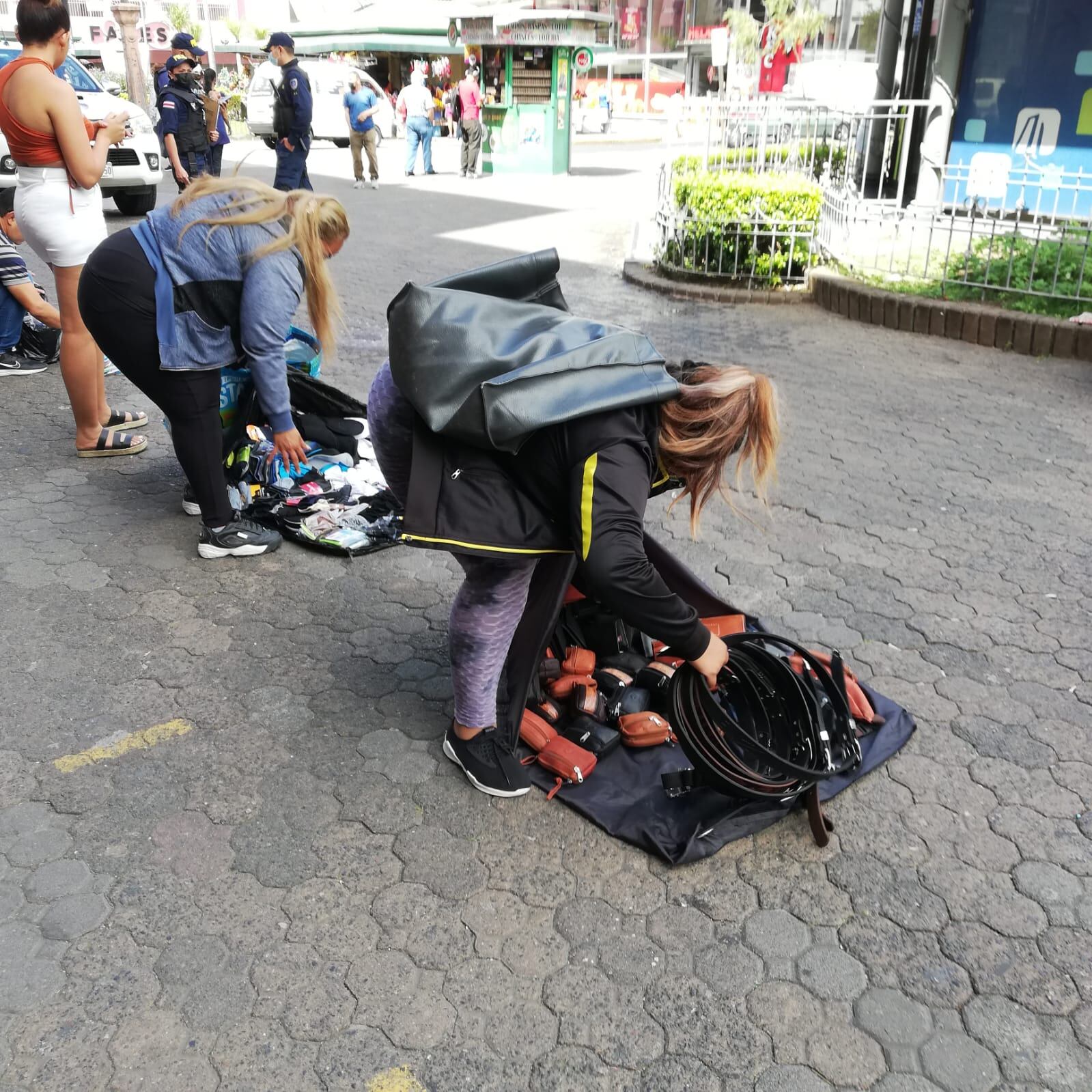 Los vendedores ambulantes de San José la están viendo horrible para conseguir qué vender y tener variedad por la crisis de los contenedores. En la foto, doña Abigail Martínez se apura a recoger su mercadería para que la policía municipal no se la decomise.
