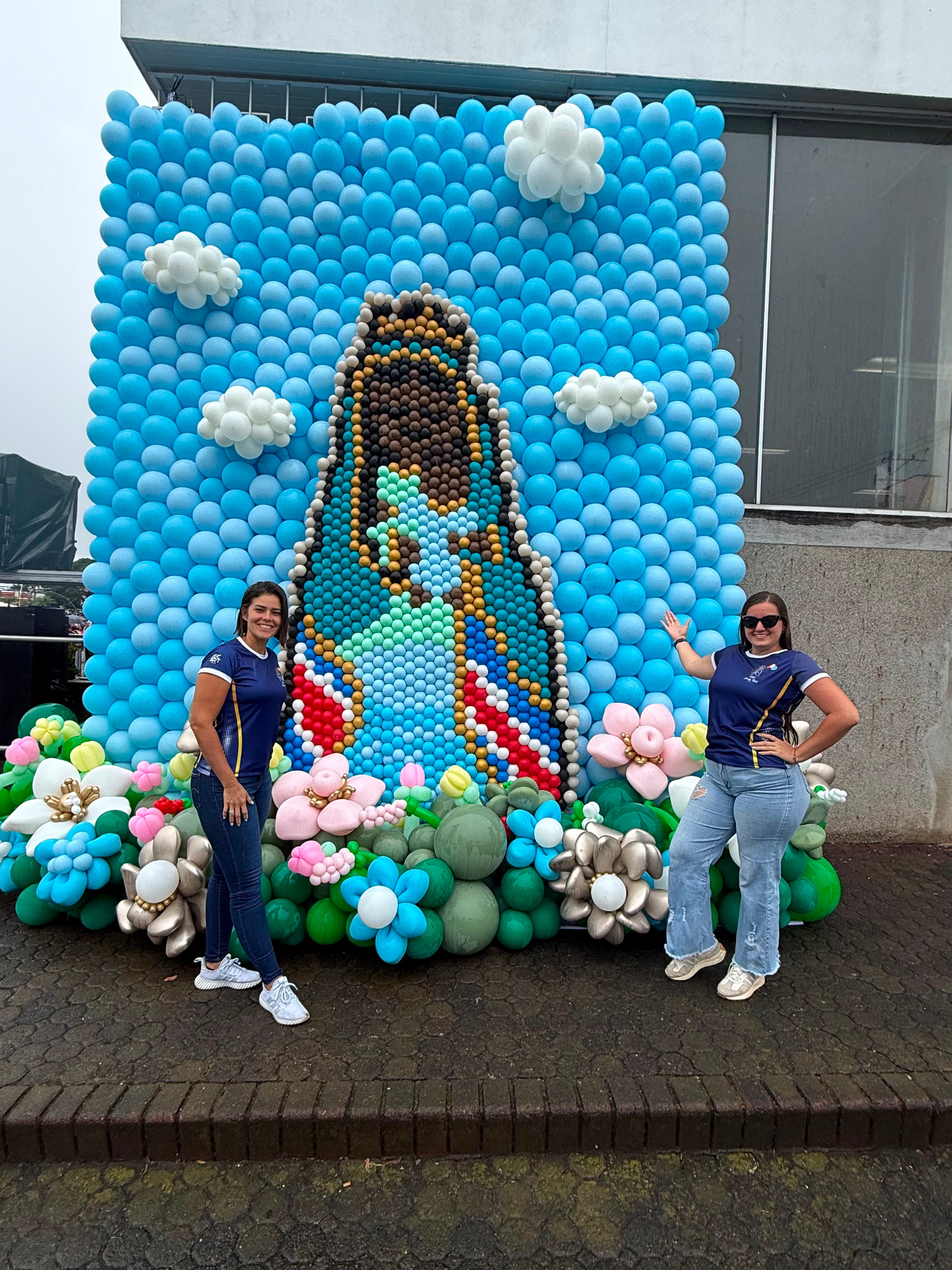 La diseñadora profesional de arte con globos Decky Ruiz, de nacionalidad venezolana y residente en Heredia, presentó una impresionante imagen de la Virgen de los Ángeles de 4,5 metros de altura, hecha con más de 4.500 globos. En la foto le acompaña la tica Priscila Bolaños (derecha) quien también participó.