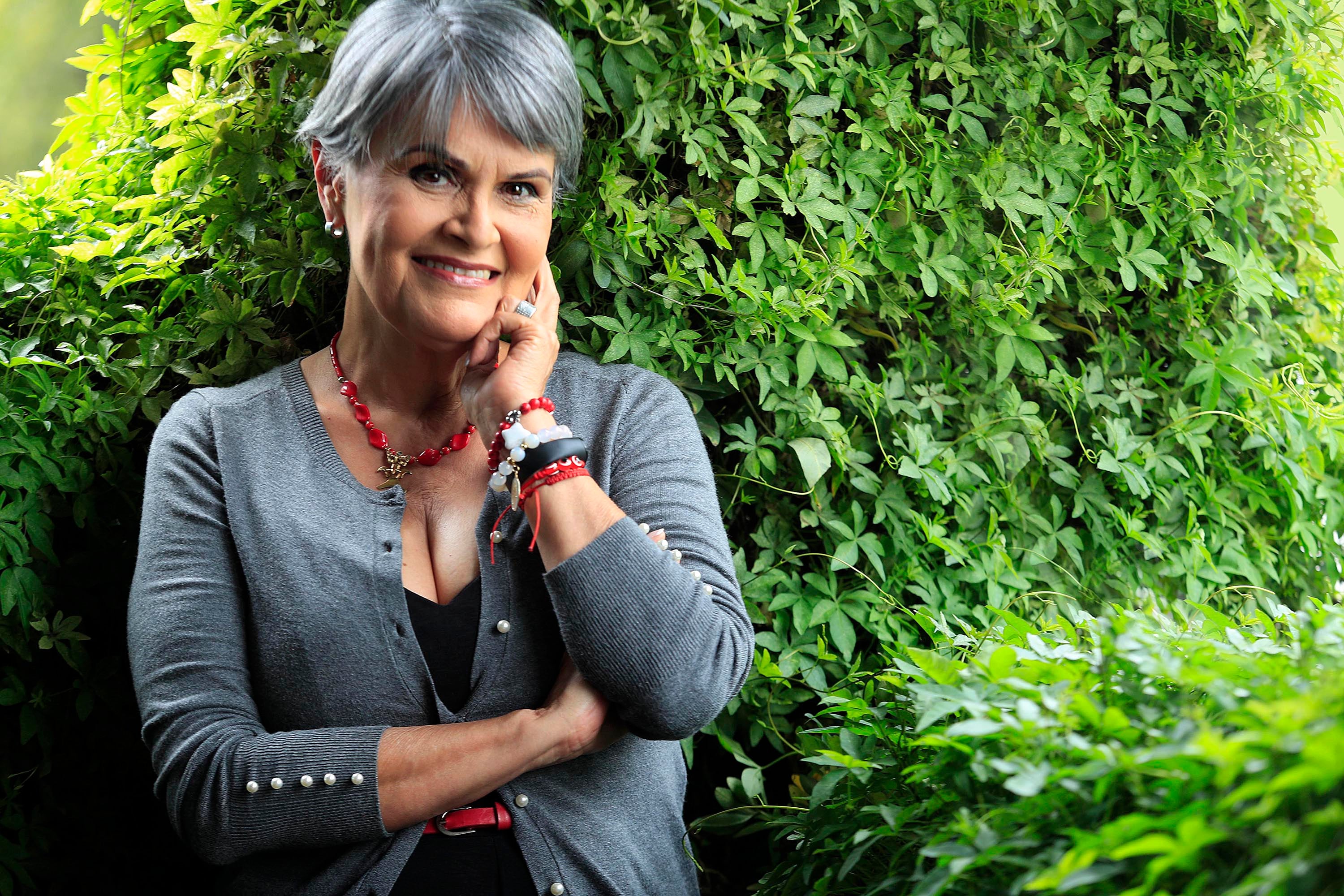 Primer plano de María Torres con arbustos de fondo