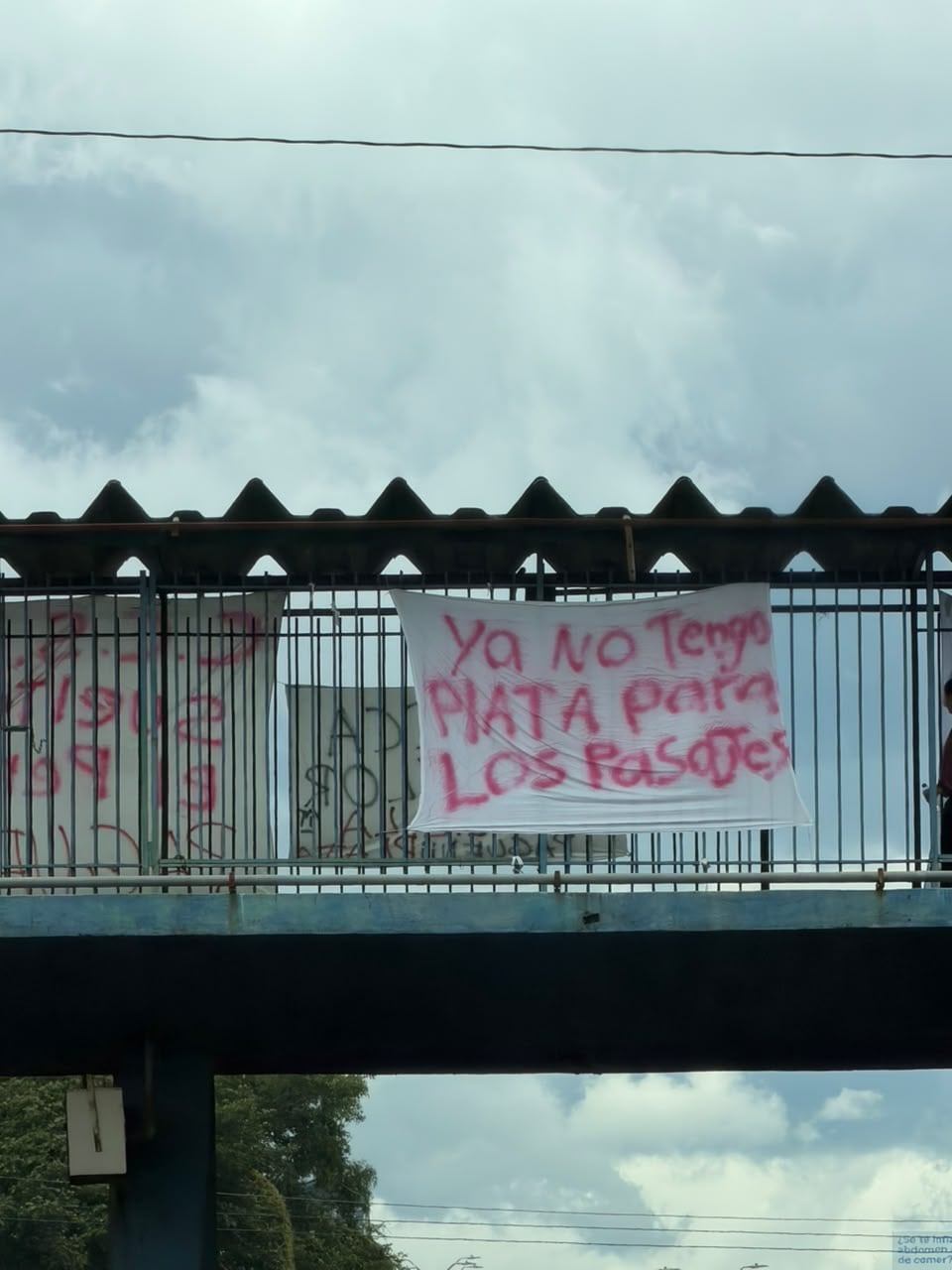 Varias mantas cuelgan del puente peatonal que se ubica frente al Hospital México. Los mensajes denuncian la problemática de pagos salariales a empleados de la CCSS. Foto: Cortesía