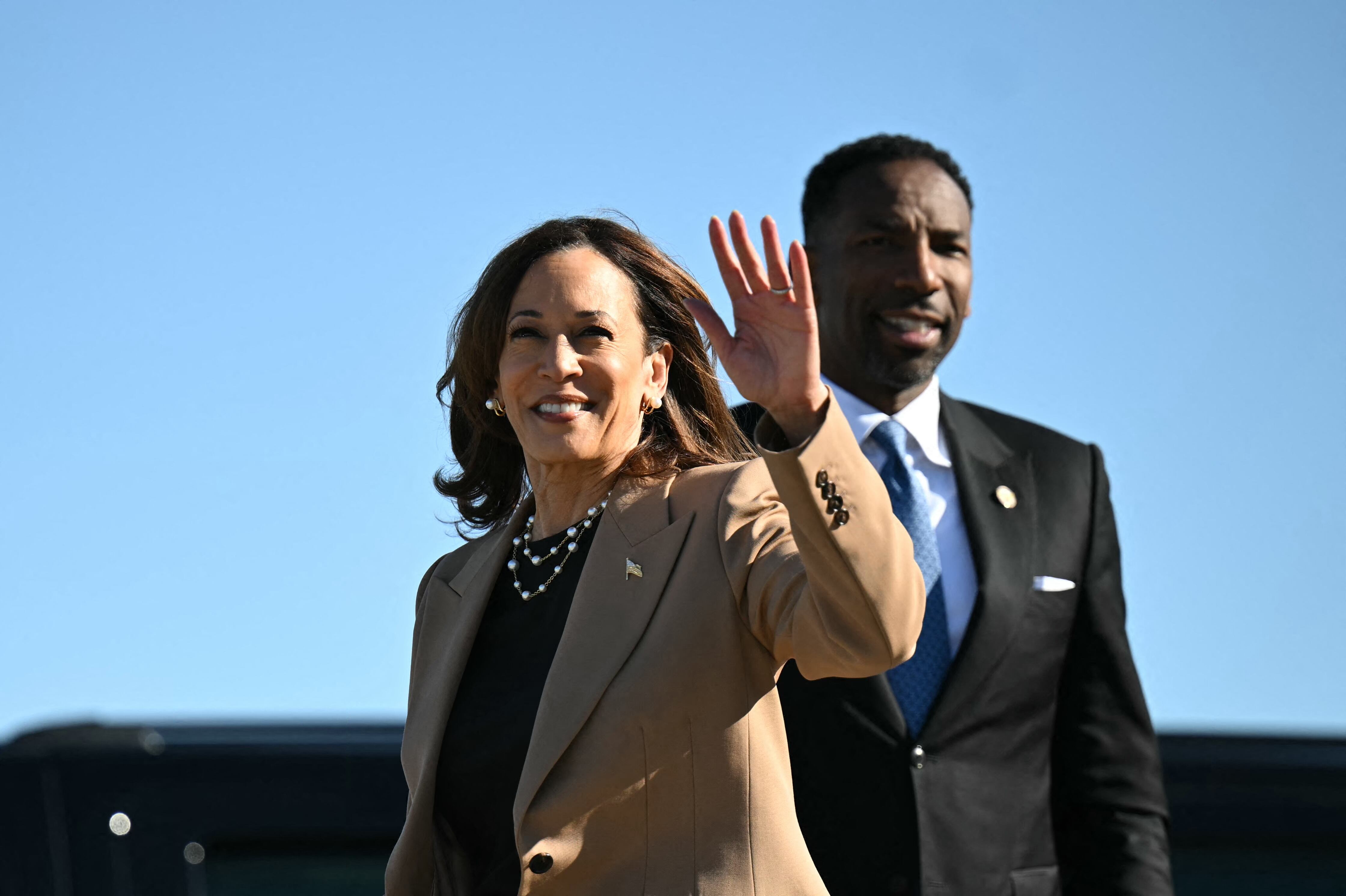 La vicepresidenta estadounidense y candidata presidencial demócrata Kamala Harris saluda a su llegada al Aeropuerto Internacional Hartsfield-Jackson en Atlanta, Georgia junto a ella el alcalde de Atlanta, Andre Dickens antes de un mitin de campaña con el expresidente estadounidense Barack Obama.