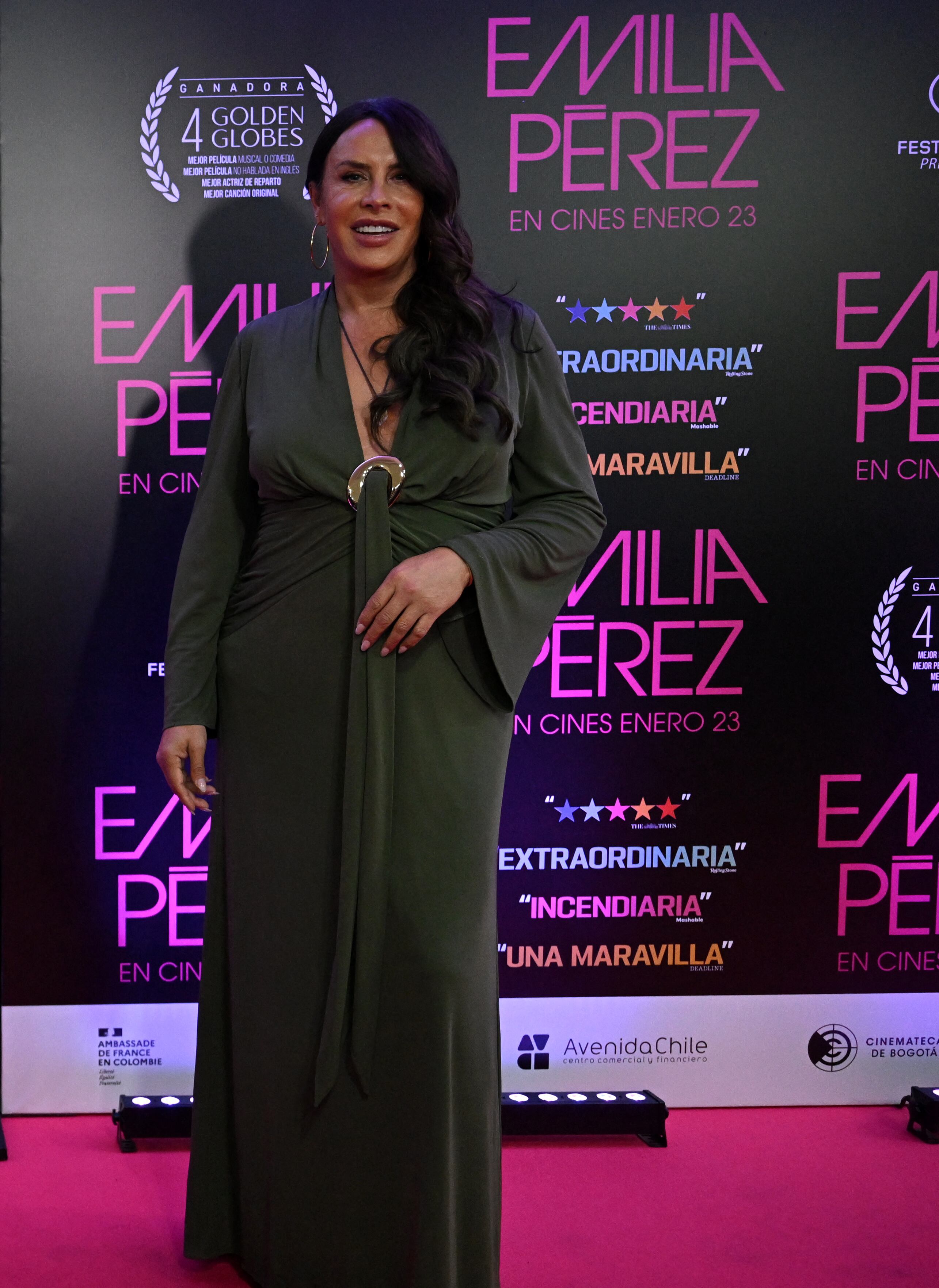 Actriz Karla Sofía Gascón posando para las cámaras, usa un vestido verde largo.