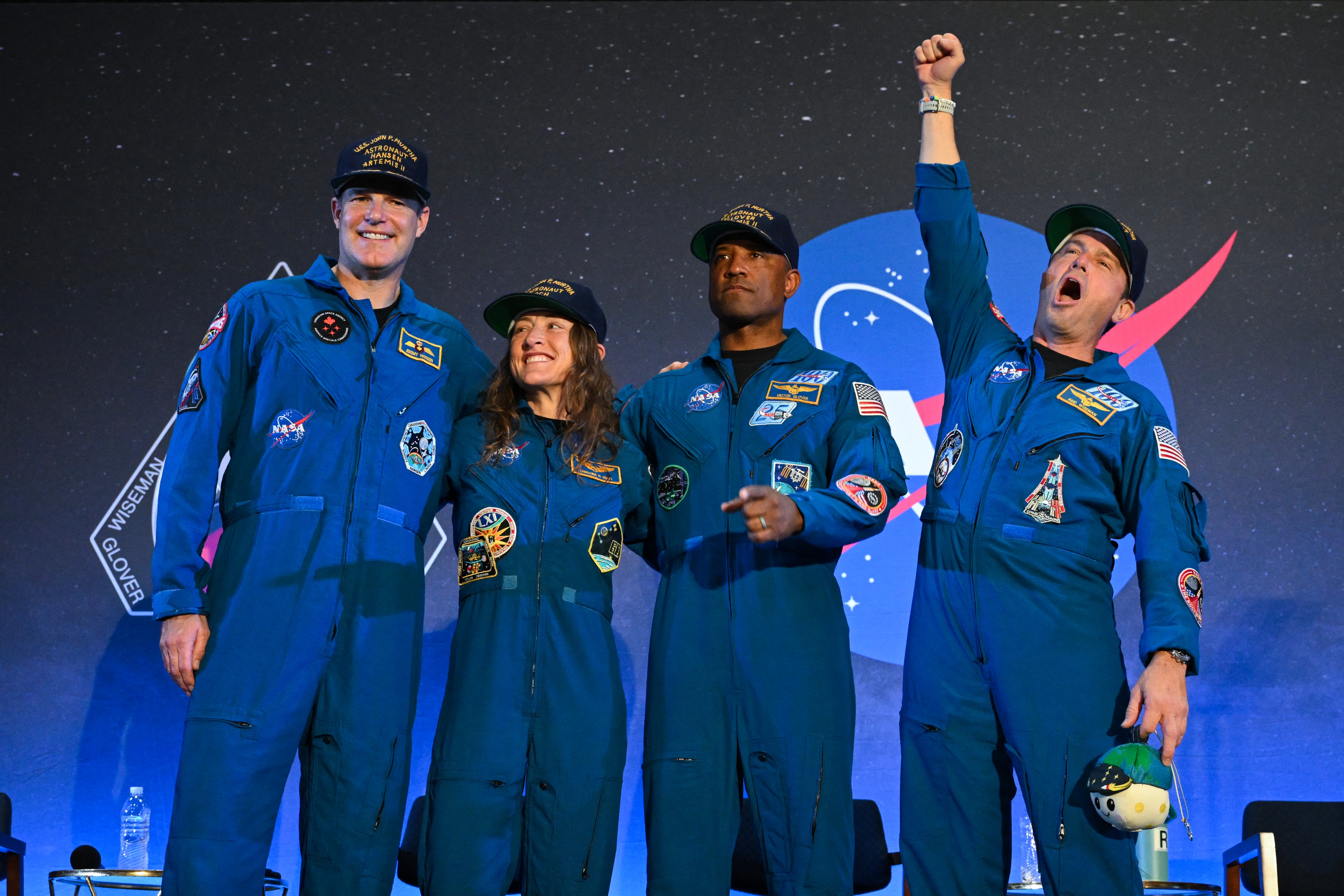 los astronautas de la misión Artemis II de la NASA —Jeremy Hansen, de la Agencia Espacial Canadiense; Christina Koch; Victor Glover; y el comandante Reid Wiseman— reaccionan durante una ceremonia de bienvenida en la Base Conjunta de Reserva de Ellington Field, en Houston, Texas.