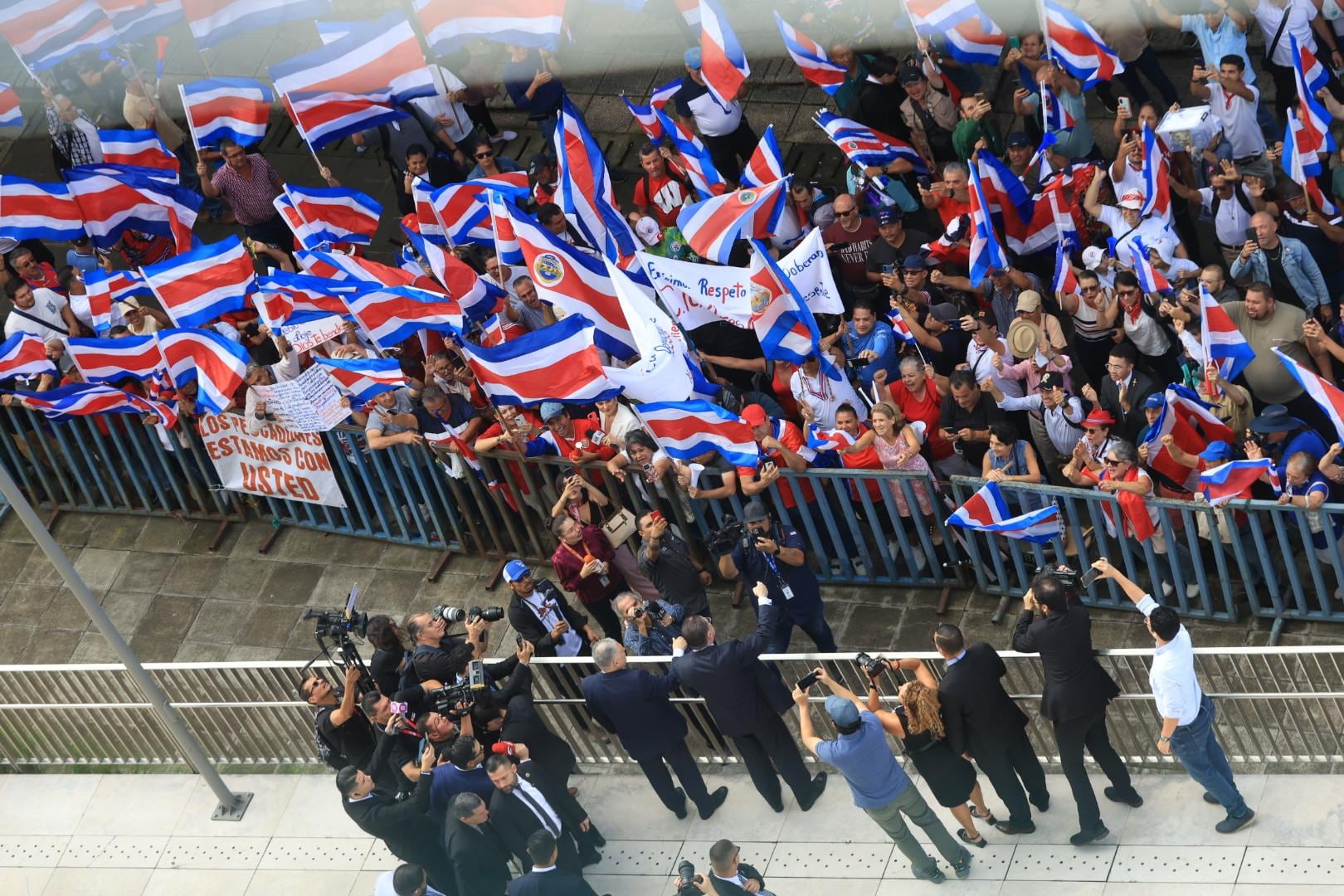 El presidente Rodrigo Chaves saluda a sus seguidores congregados en las afueras de la Asamblea Legislativa. Chaves comparece este 14 de noviembre ante la comisión especial que estudia la solicitud del TSE de levantar la inmunidad del mandatario.