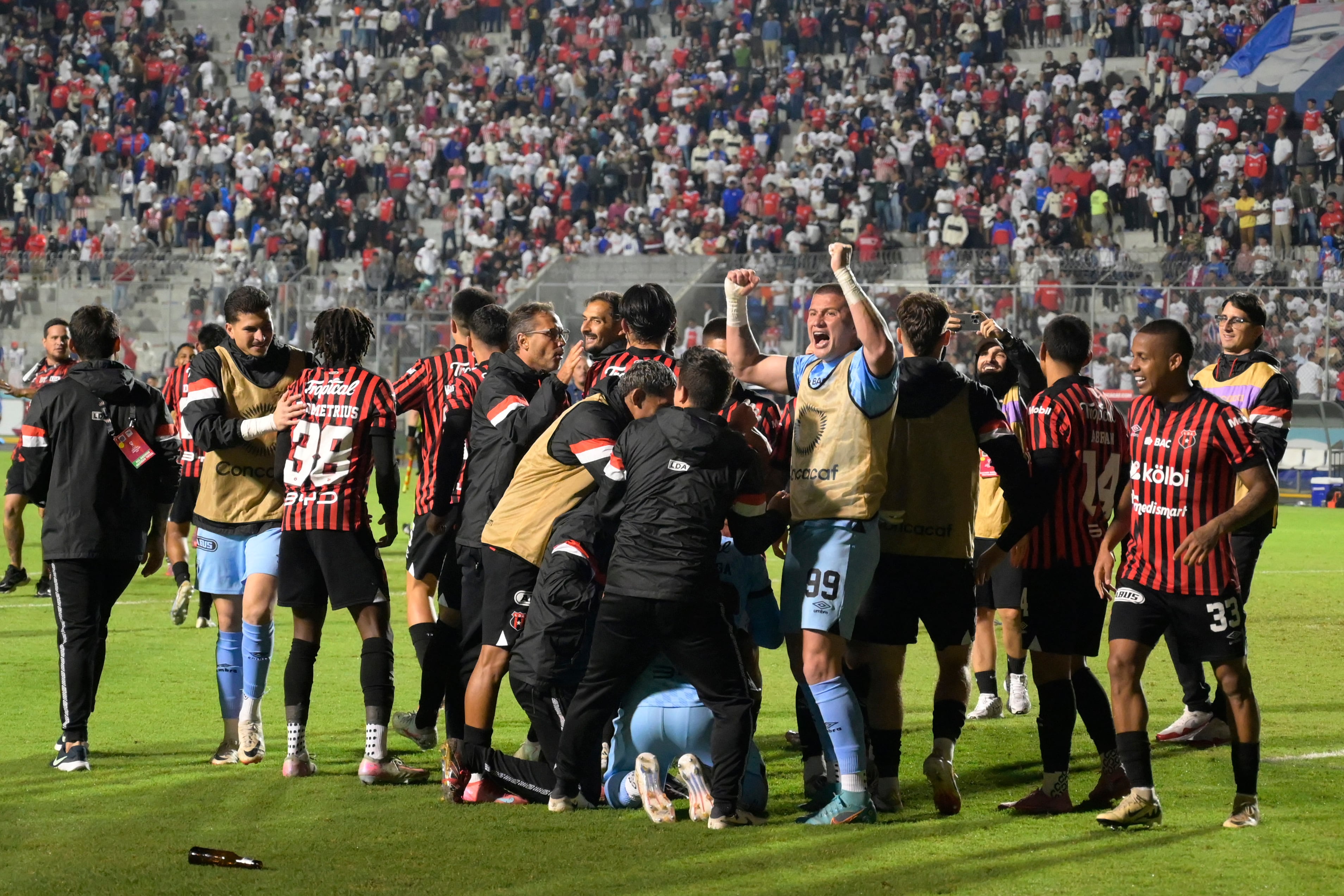 Alajuelense's players celebrate after winning the penalty shootout and the second leg of the CONCACAF Central American Cup semifinal football match between Honduras's Olimpia and Costa Rica's Alajuelense at the National Stadium Jose de la Paz Herrera in Tegucigalpa on October 30, 2025. (Photo by Orlando SIERRA / AFP)