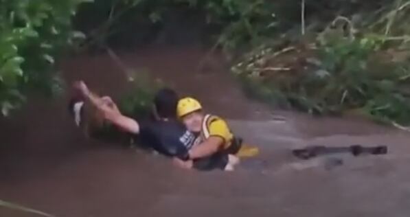 El bomberos Gabriel Oses junto a sus compañeros hicieron un rescate de película cuando un hombre fue arrastrado por una cabeza de agua y su vida dependía solo de la rama de un árbol en San José. Foto: Captura de video