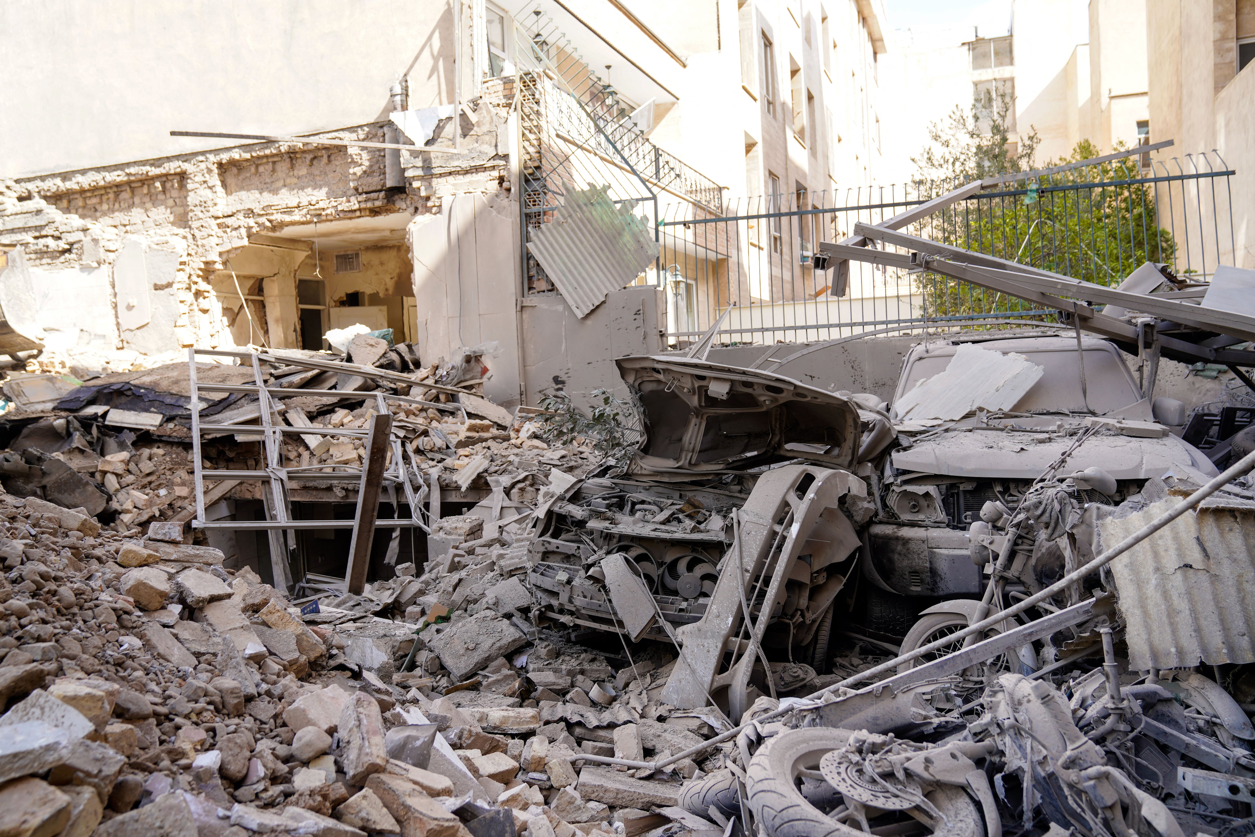 En la imagen, escombros y restos que cubren un vehículo destruido tras un ataque con misiles contra un vecindario de la capital iraní, Teherán, el 28 de febrero de 2026.