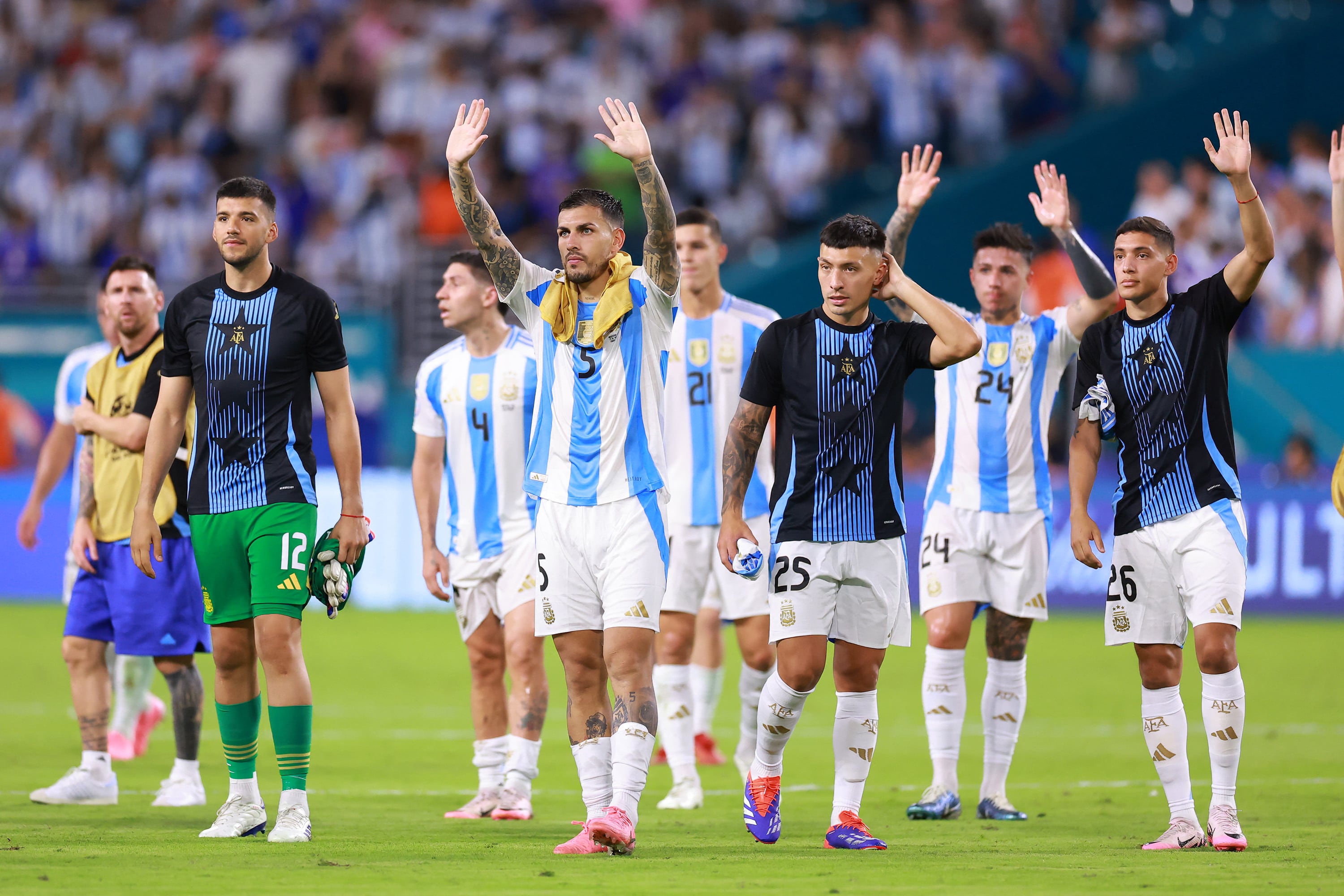 MIAMI GARDENS, FLORIDA - JUNE 29: Leandro Paredes of Argentina (C) and teammates wave to fans as they celebrate the team's victory and progression to the quarter finals after during the CONMEBOL Copa America 2024 Group A match between Argentina and Peru at Hard Rock Stadium on June 29, 2024 in Miami Gardens, Florida. Hector Vivas/Getty Images/AFP (Photo by Hector Vivas / GETTY IMAGES NORTH AMERICA / Getty Images via AFP)