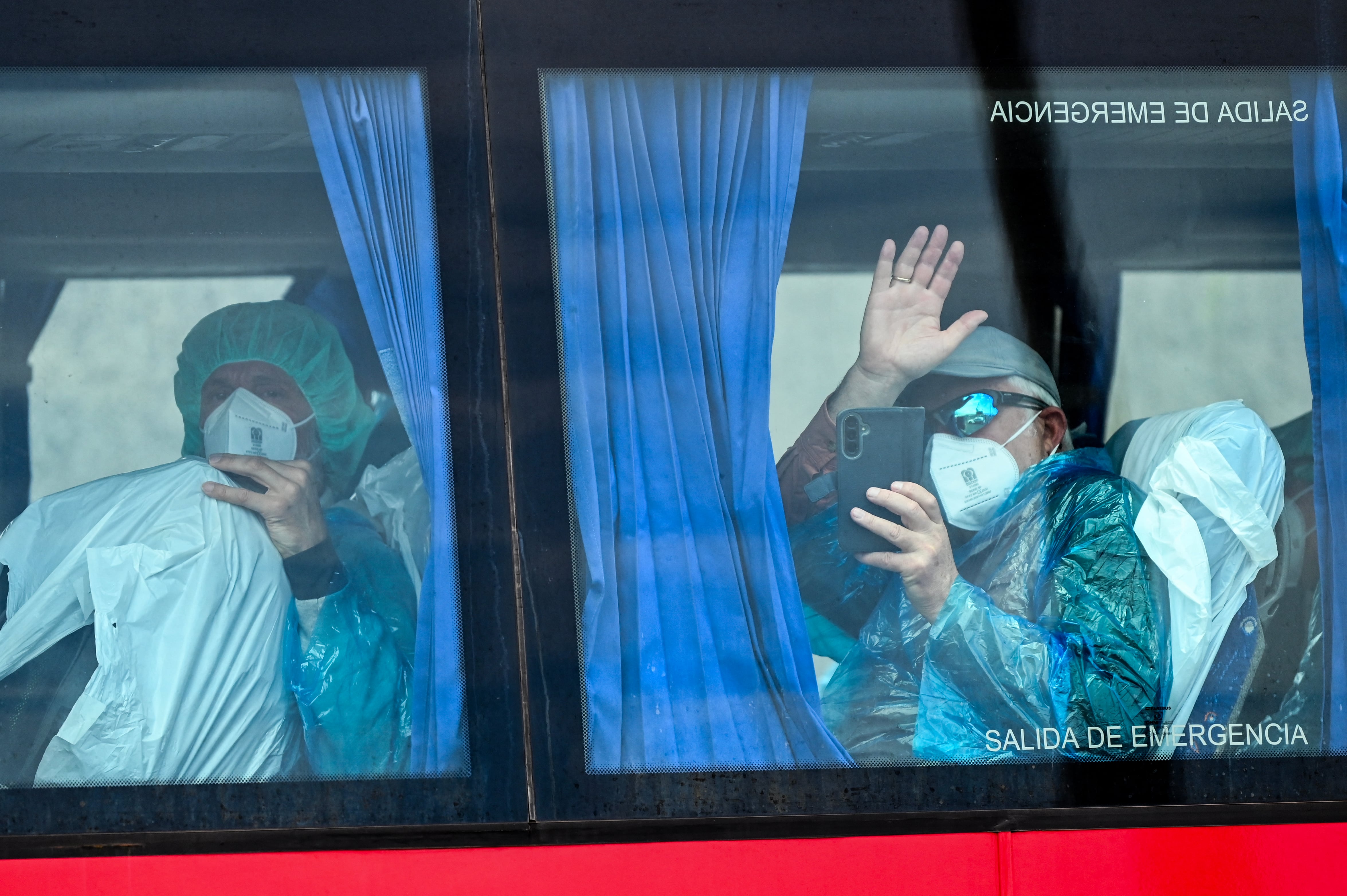 Pasajeros con equipo de protección abordan un autobús militar tras ser evacuados del crucero neerlandés MV Hondius, afectado por un brote mortal de hantavirus, en el puerto industrial de Granadilla de Abona, en Tenerife, España, este 10 de mayo de 2026. Los casi 150 pasajeros serán repatriados a distintos países tras varias semanas en altamar. Foto: JORGE GUERRERO / AFP.